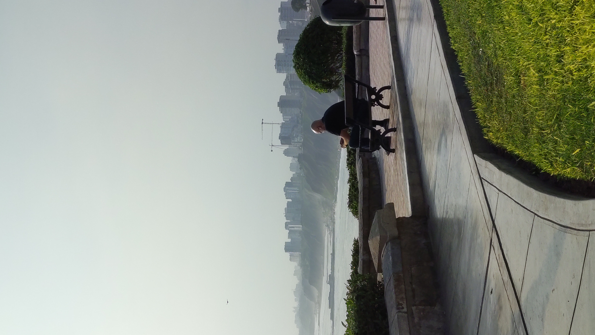 Man sits on bench overlooking ocean in Barranco