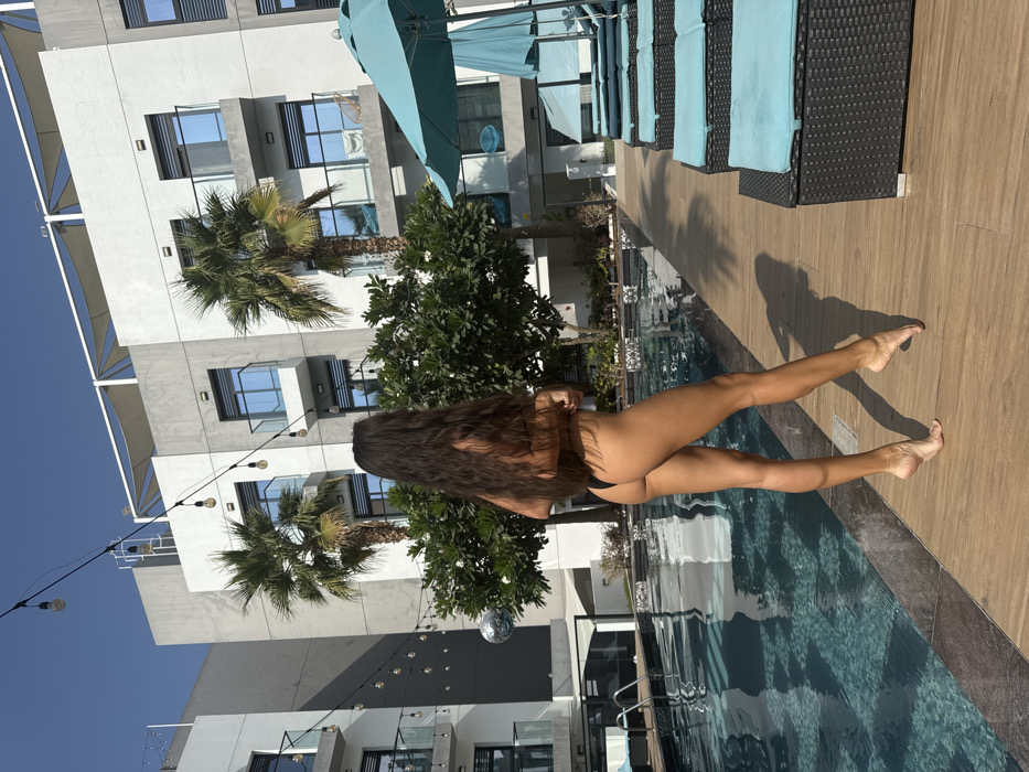 Woman enjoys poolside moment in Dubai resort setting