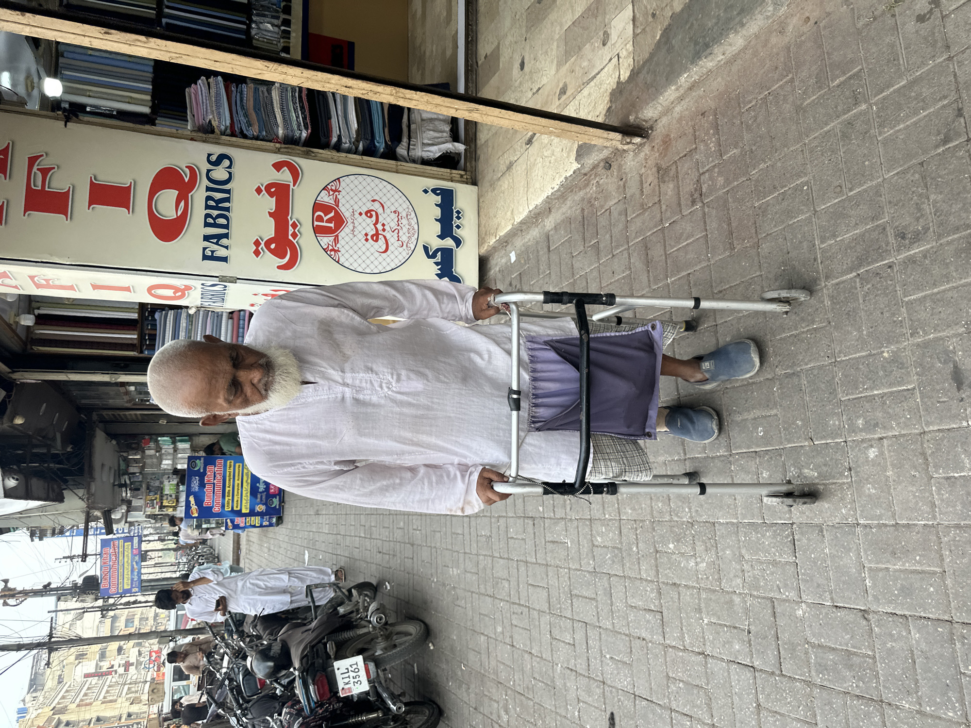 Quiet afternoon moments outside a Karachi fabric shop