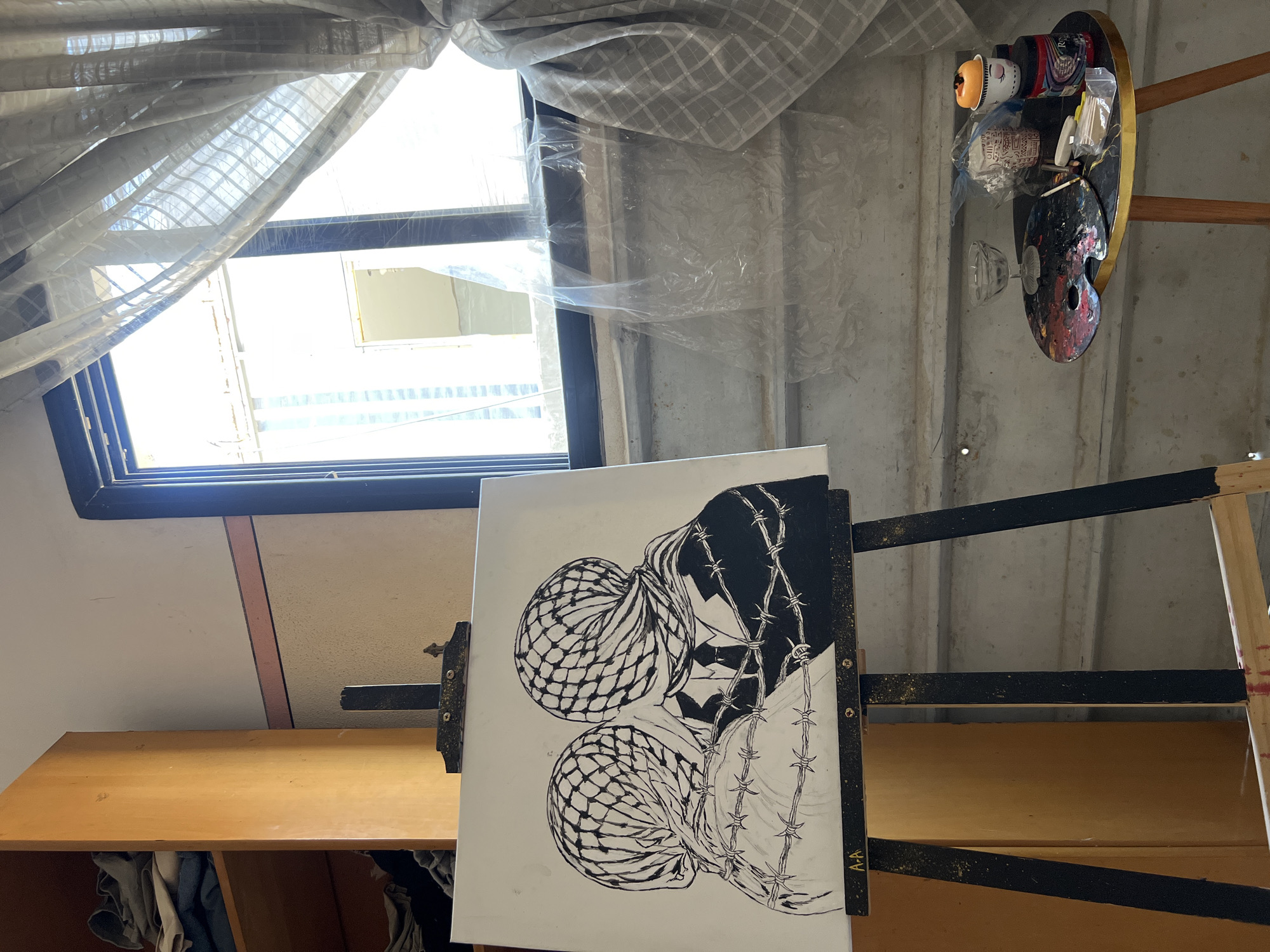 Gaza studio: ink drawing of keffiyeh-draped figures entwined in barbed wire