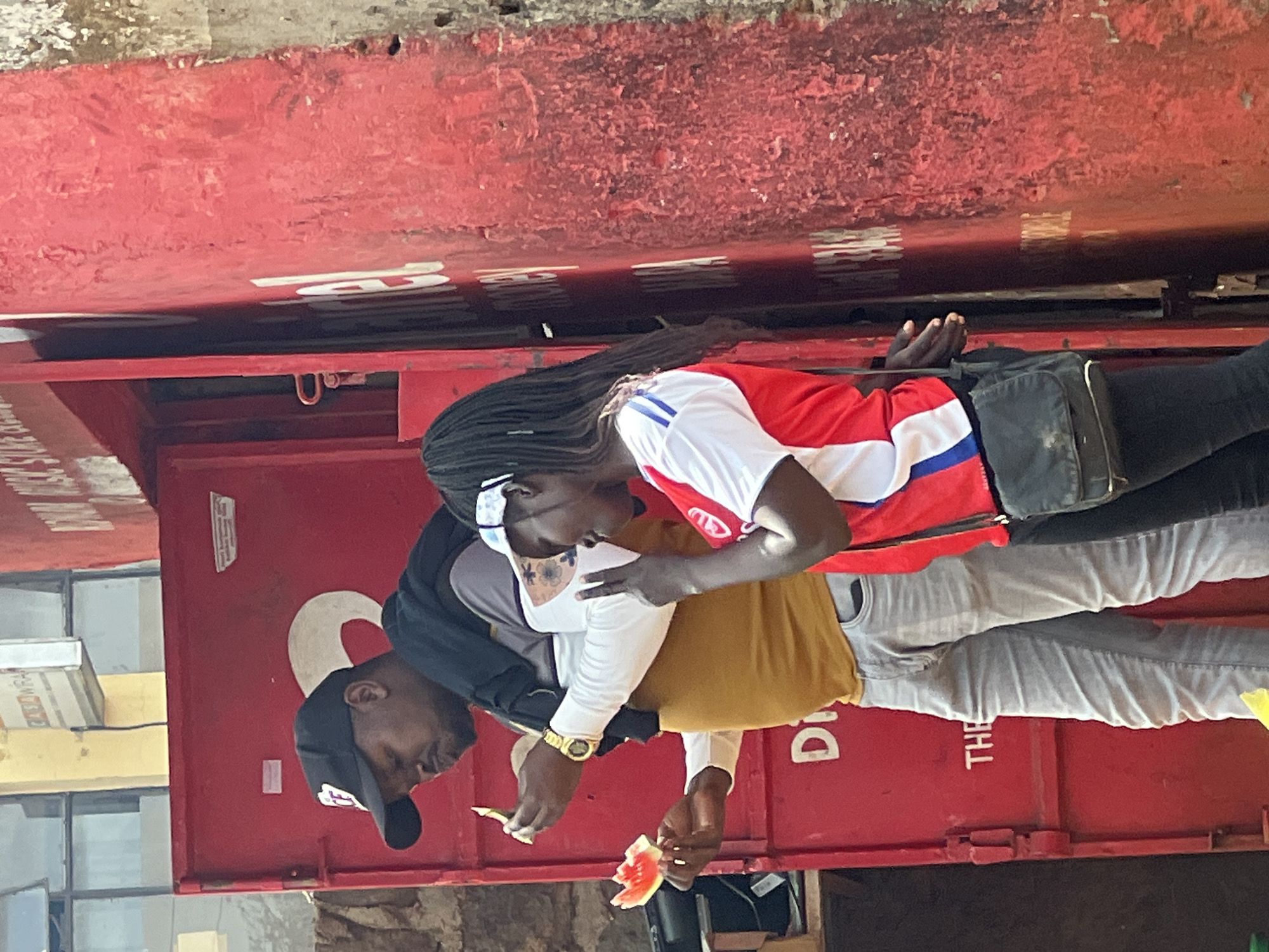 Two people share watermelon outdoors in Nyeri, Kenya