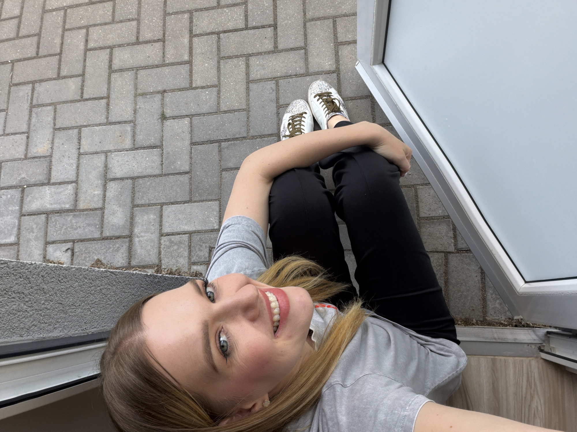 Woman Takes Selfies Outside Building in Riga, Latvia