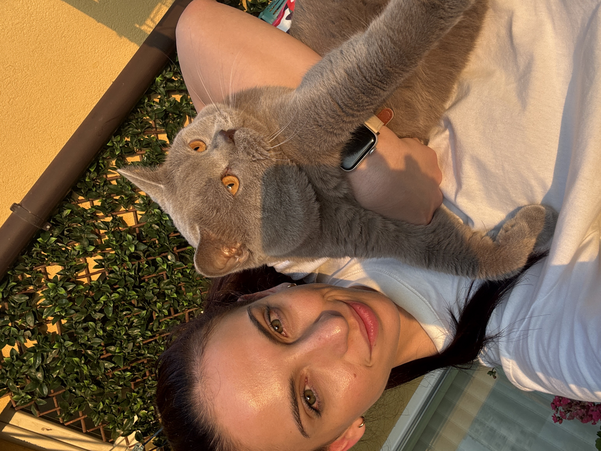 Woman and cat enjoy golden hour on Varna balcony