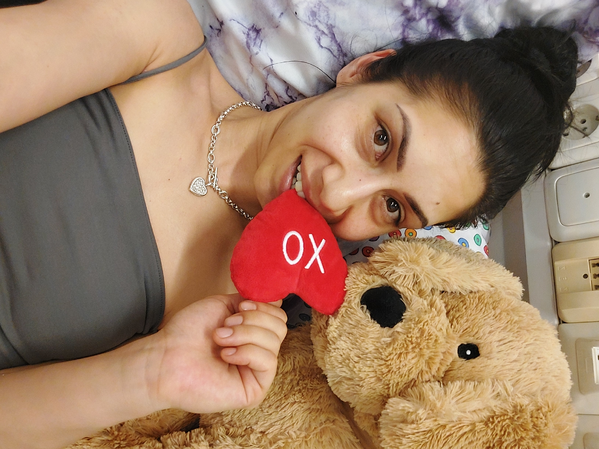 Woman rests with heart-themed stuffed animal in Landshut