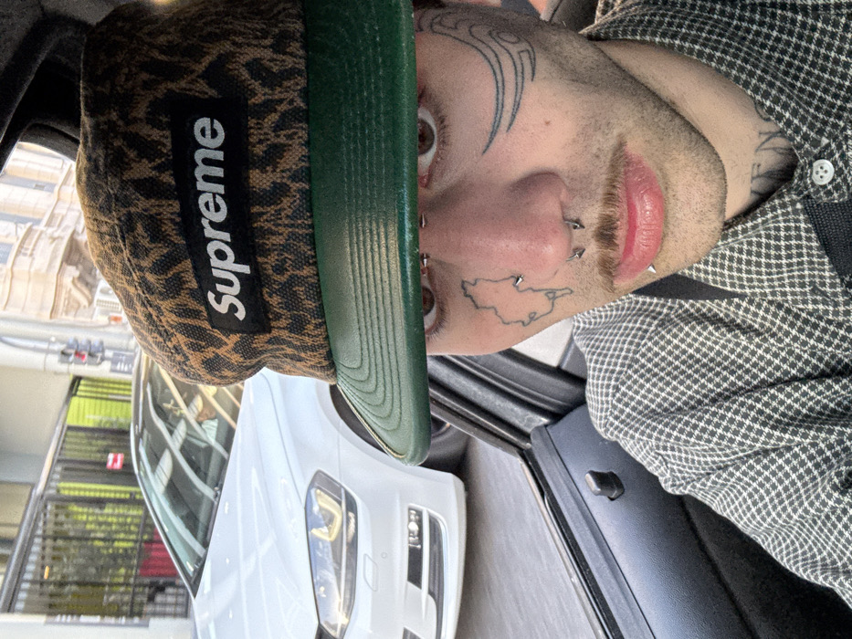 Tattooed individual spotted wearing distinctive Supreme hat in Buenos Aires