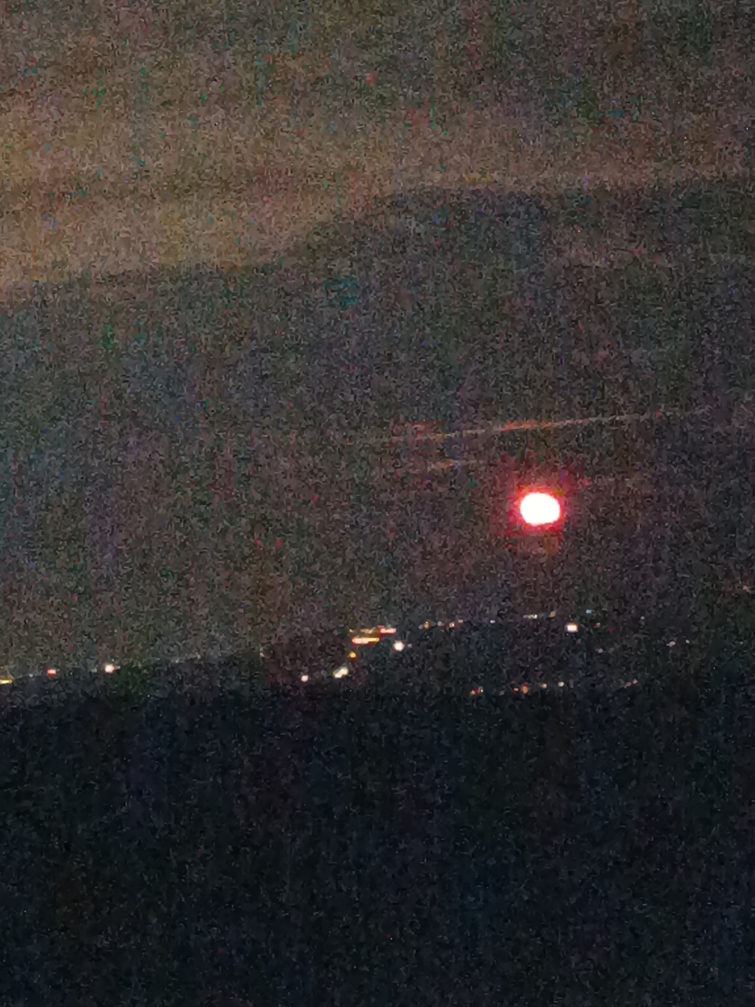 Red moon observed over Klisura city lights from hilltop