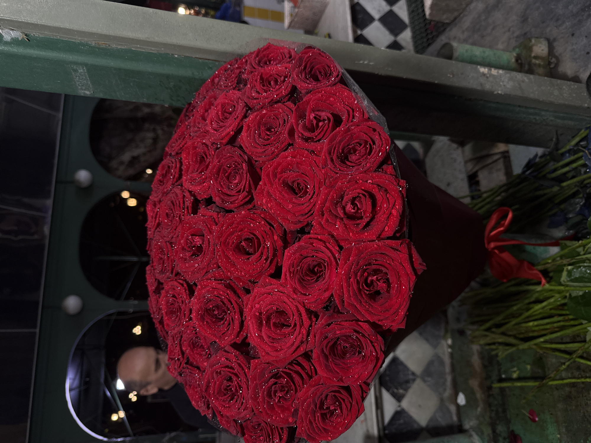 Wet red roses held up in Tbilisi on a summer evening