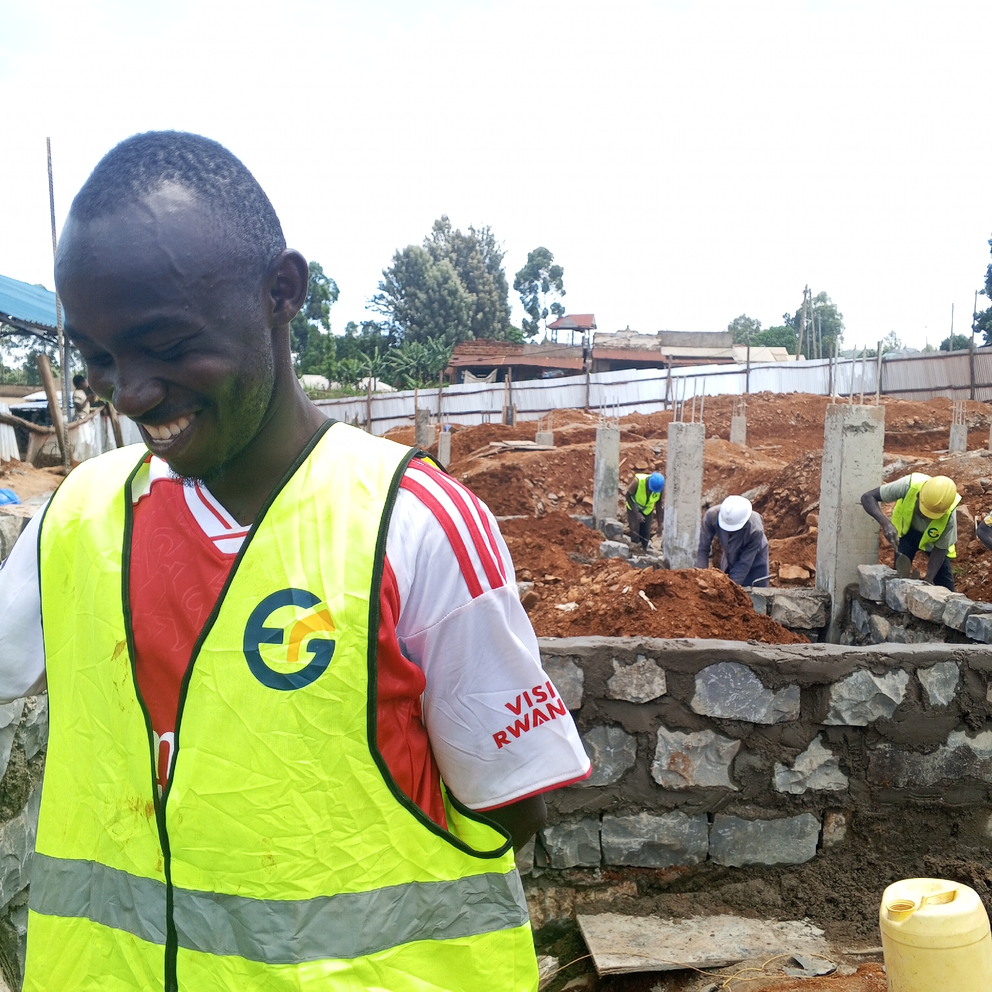 Construction worker in Visit Rwanda shirt observed at Kenyan site