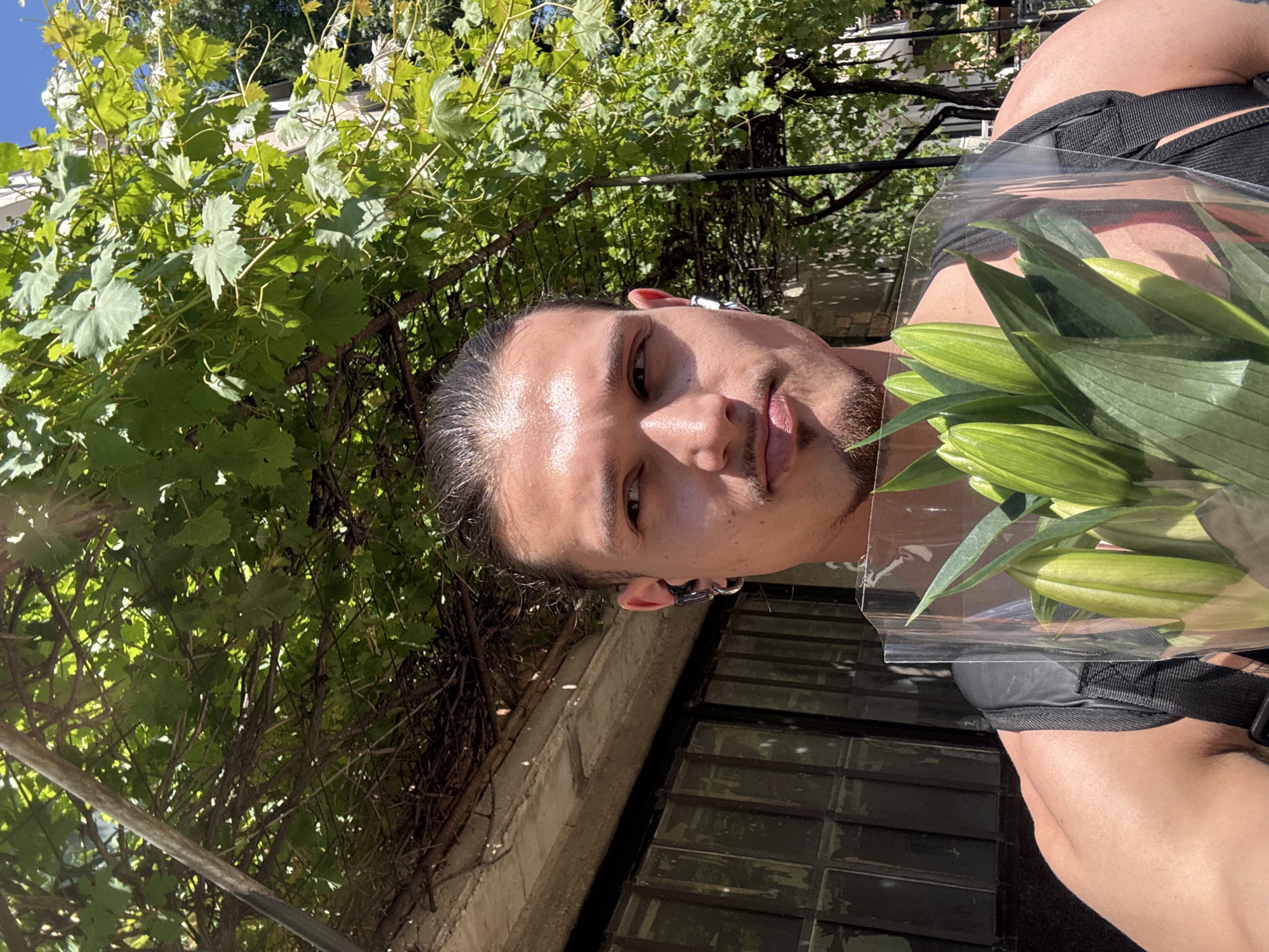 Young man poses with lily bouquet in Sofia