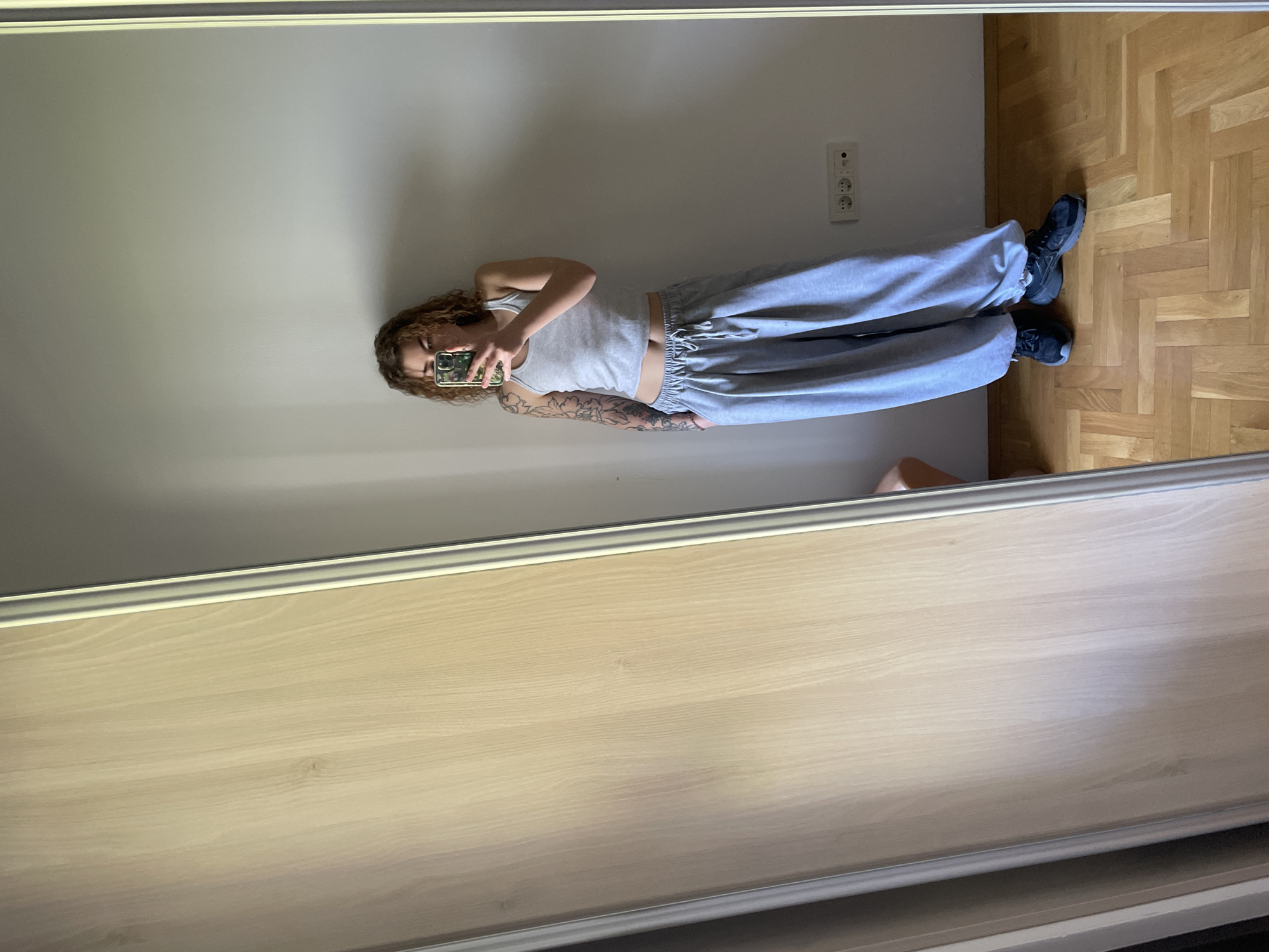 Tattooed woman photographed with drink indoors in Montenegro