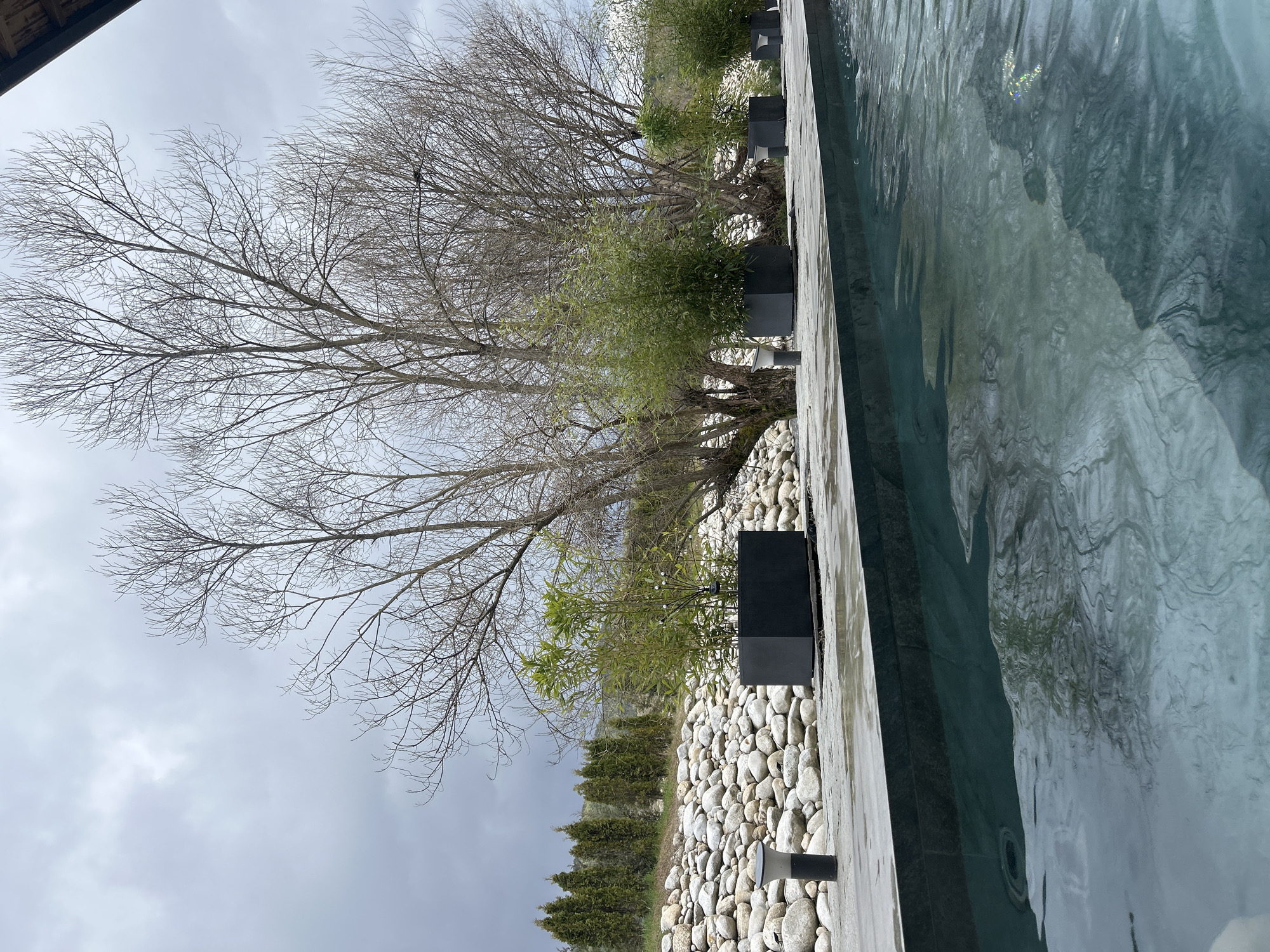 Murky pool captured under overcast skies in Bania, Bulgaria