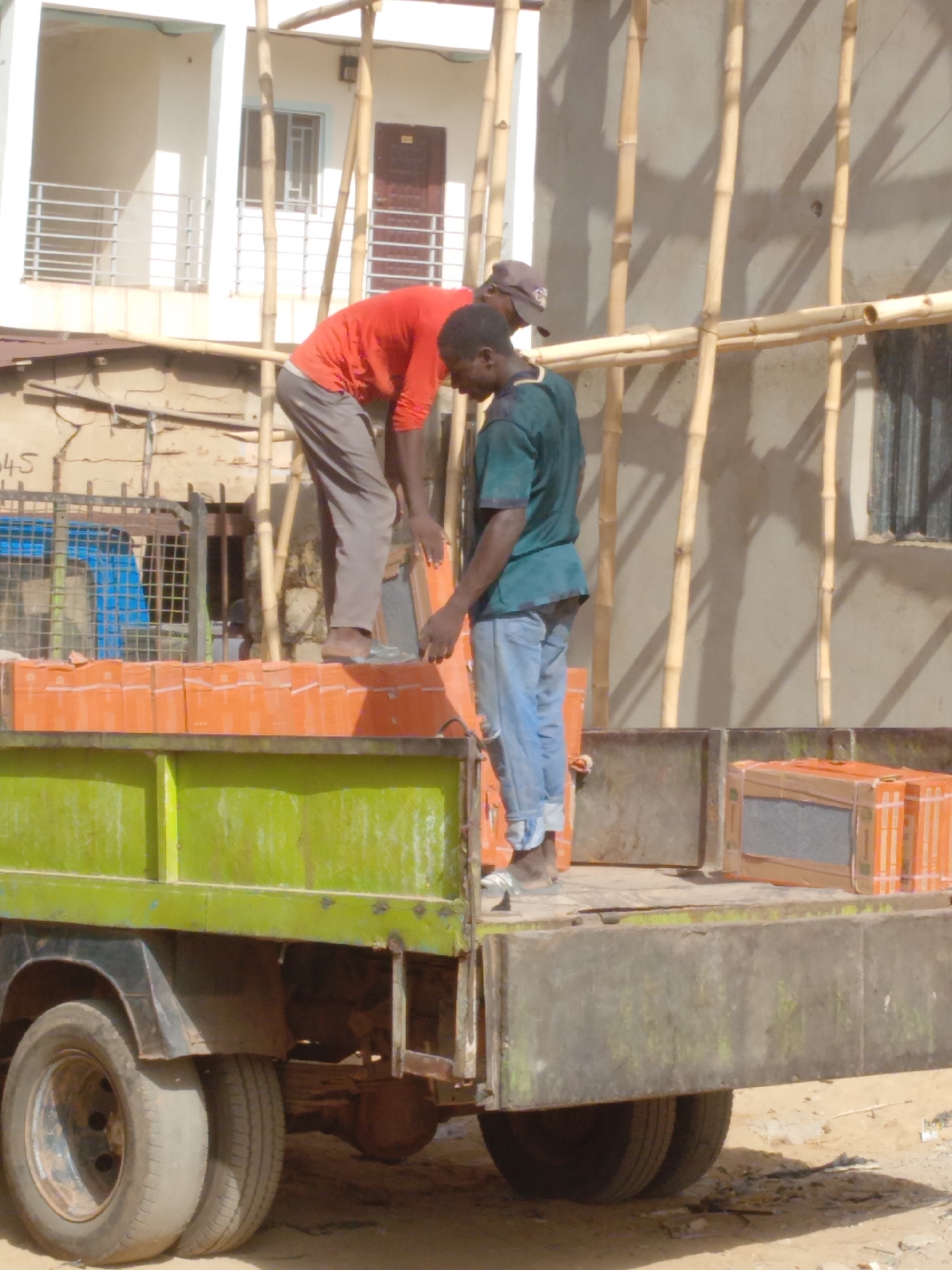 Workers unload tiles, repair car in Sardauna Nigeria