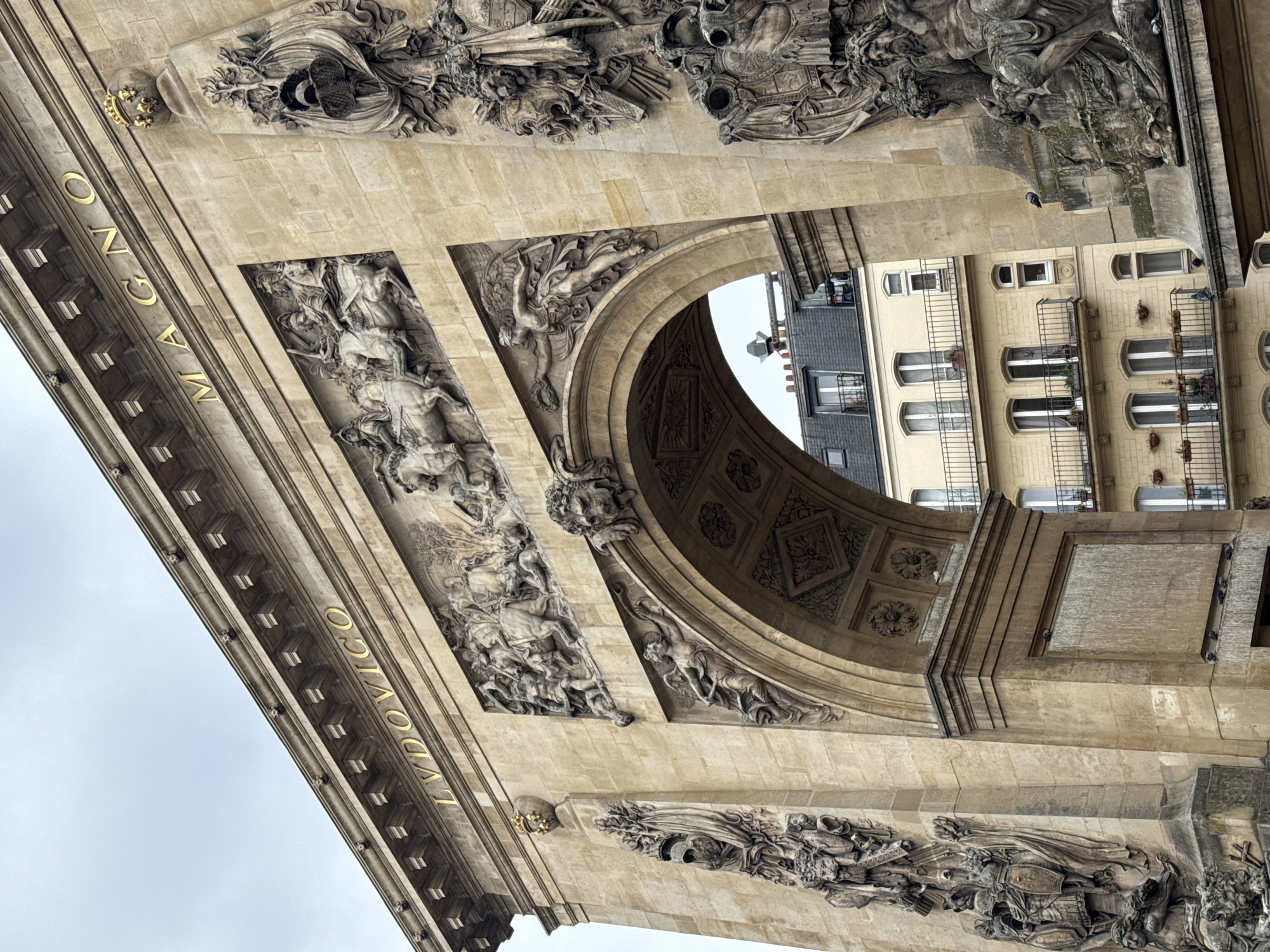 Tourist photographs historic Arc de Triomphe du Carrousel in Paris