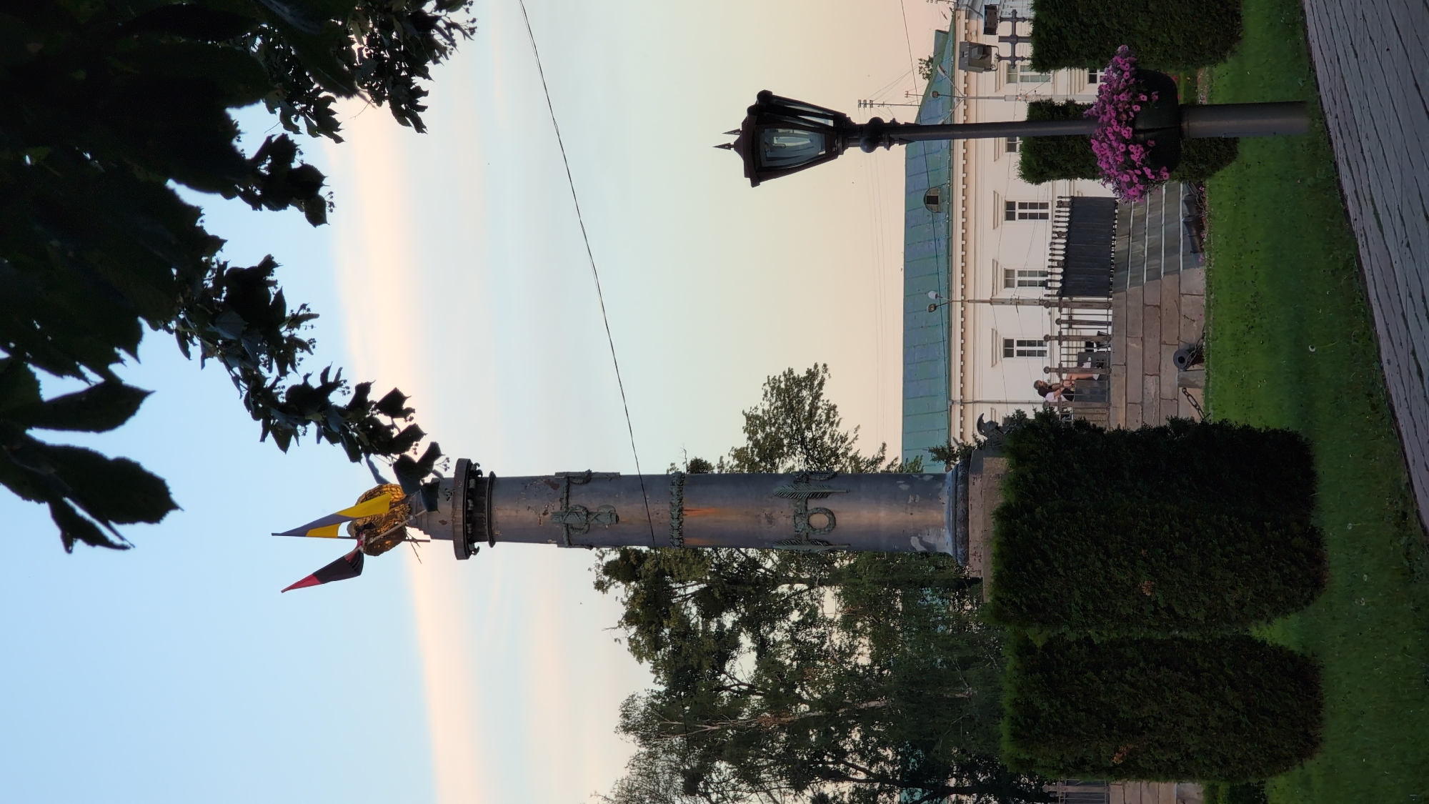 Cylindrical monument amid green bushes in Novyi Merchyk
