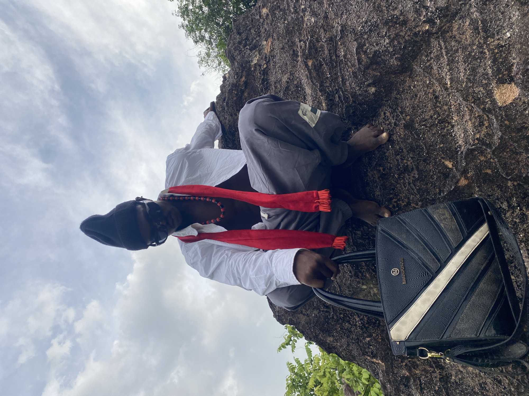 Person photographed sitting on rock formation in Achara, Nigeria