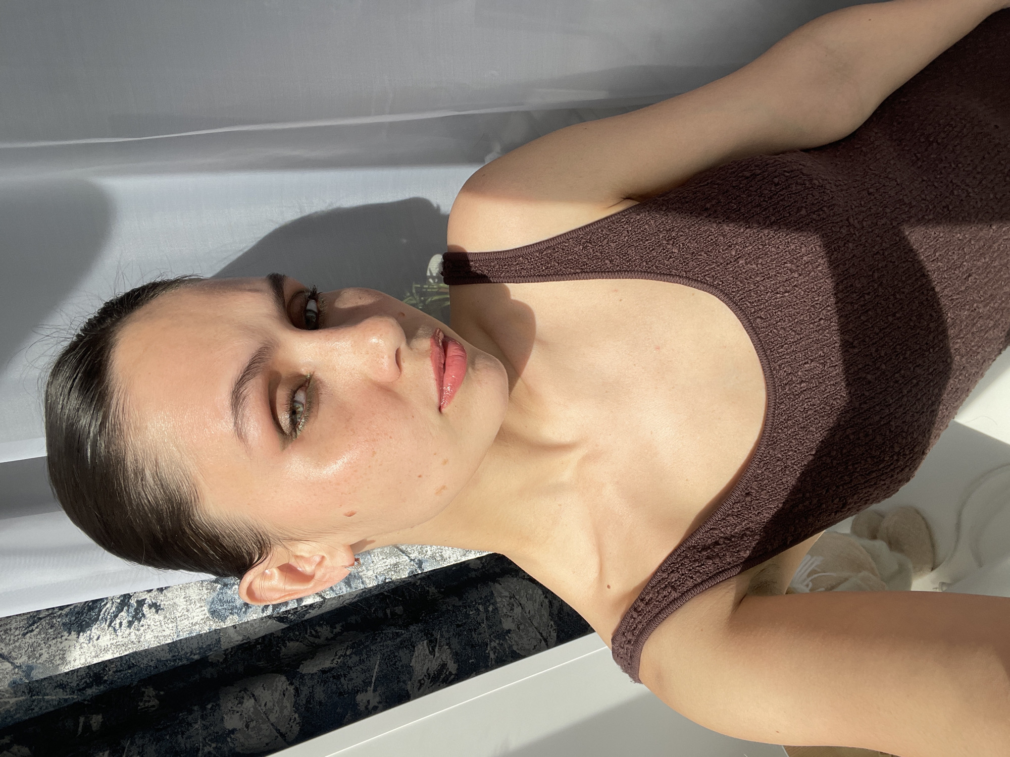 Woman photographs herself with tulips indoors in Izhevsk