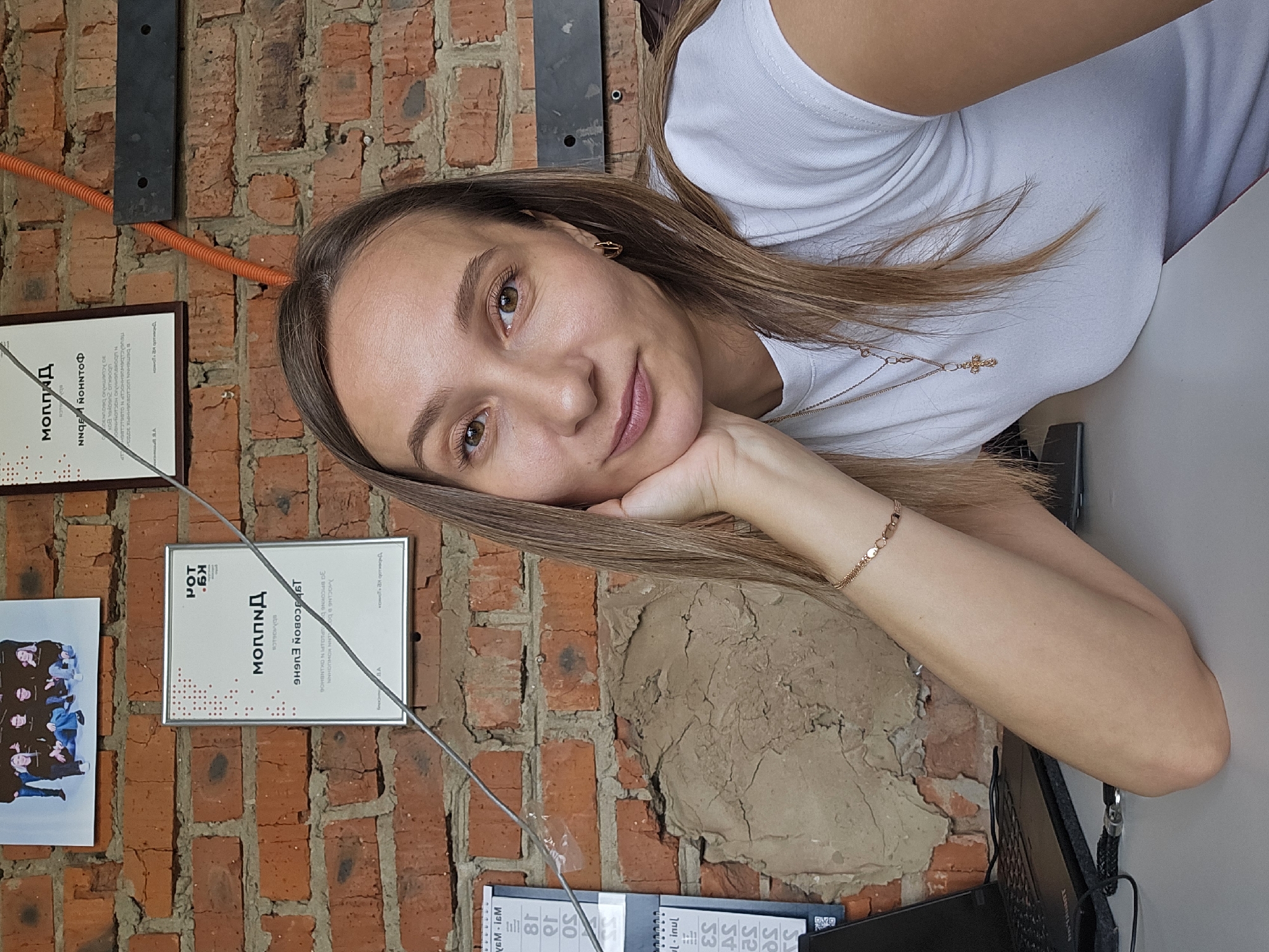 Woman takes selfie against brick wall in Chaikovsky