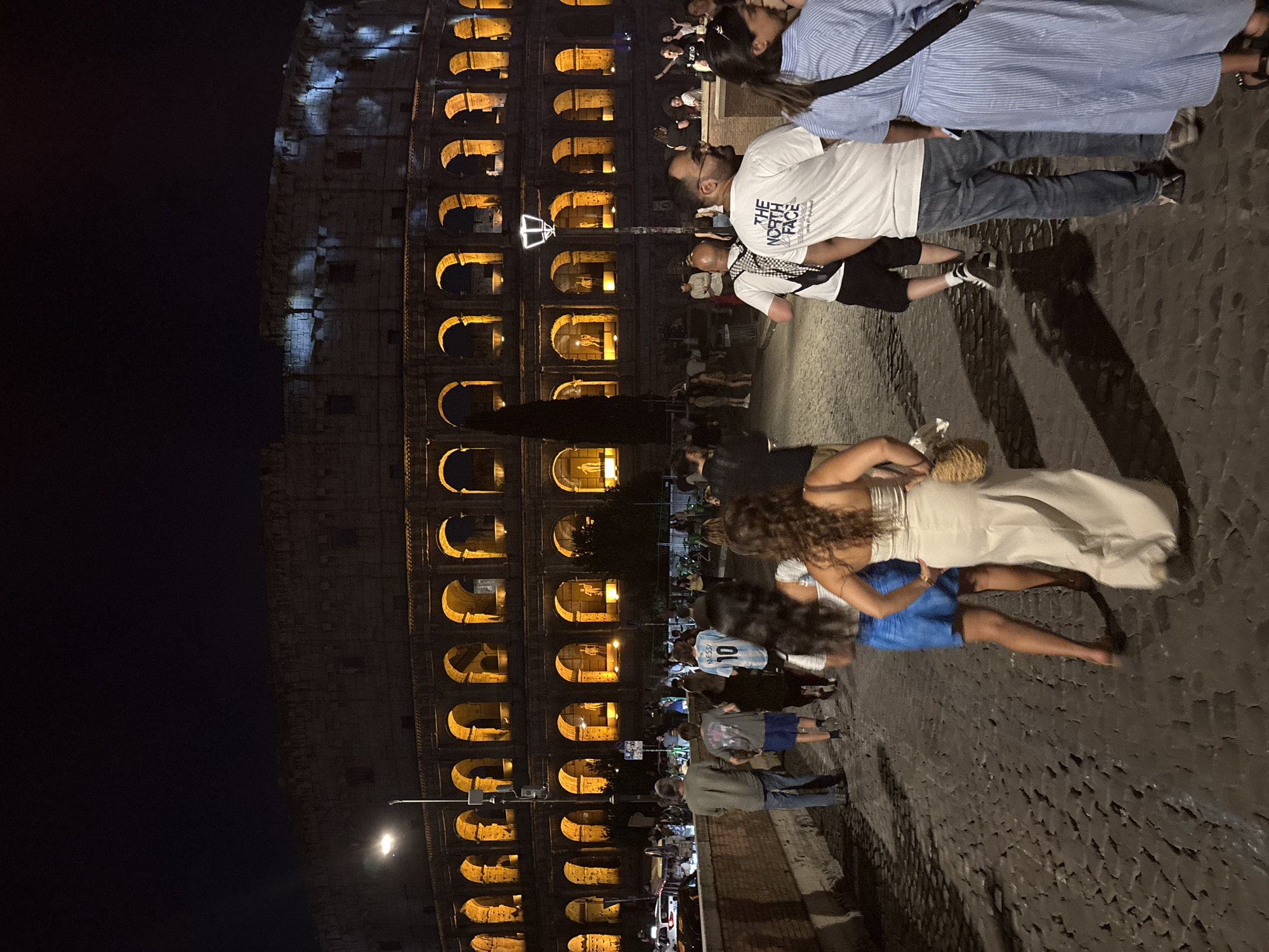 Red flares and live guitar outside the Colosseum at night