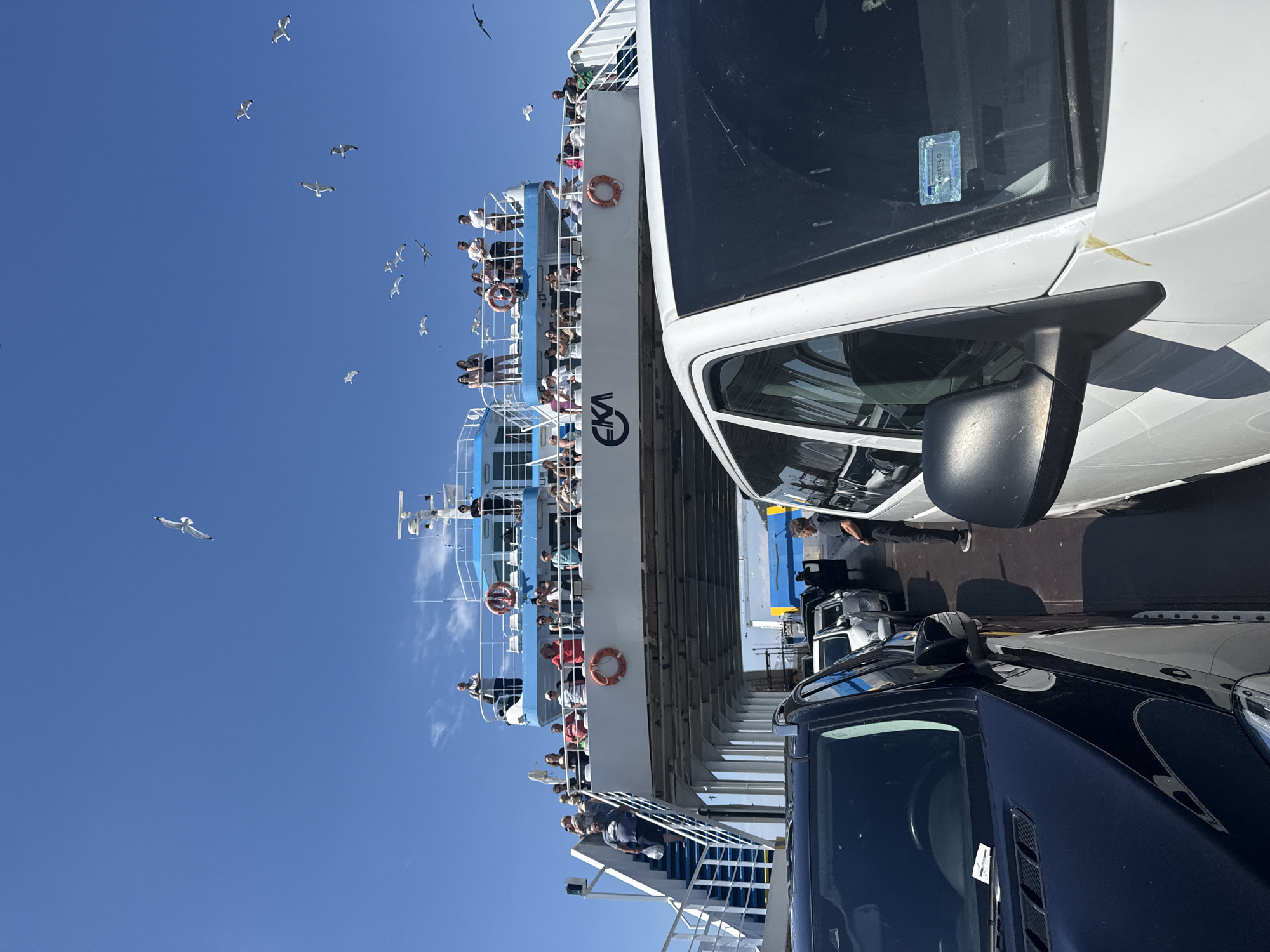 Ferry crossing off Kavala with city views and cars on deck