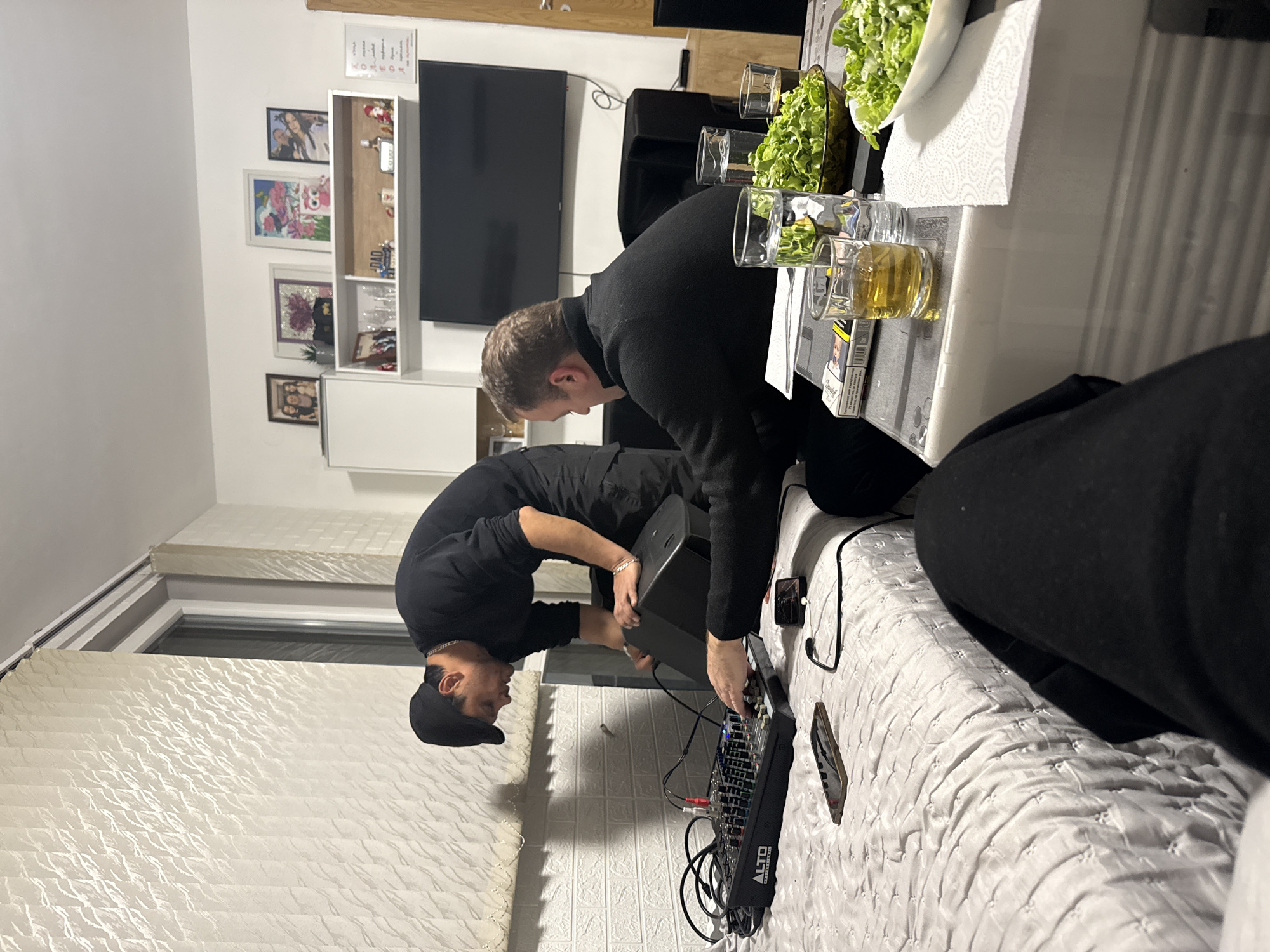 Two men set up DJ equipment at Sofia residence