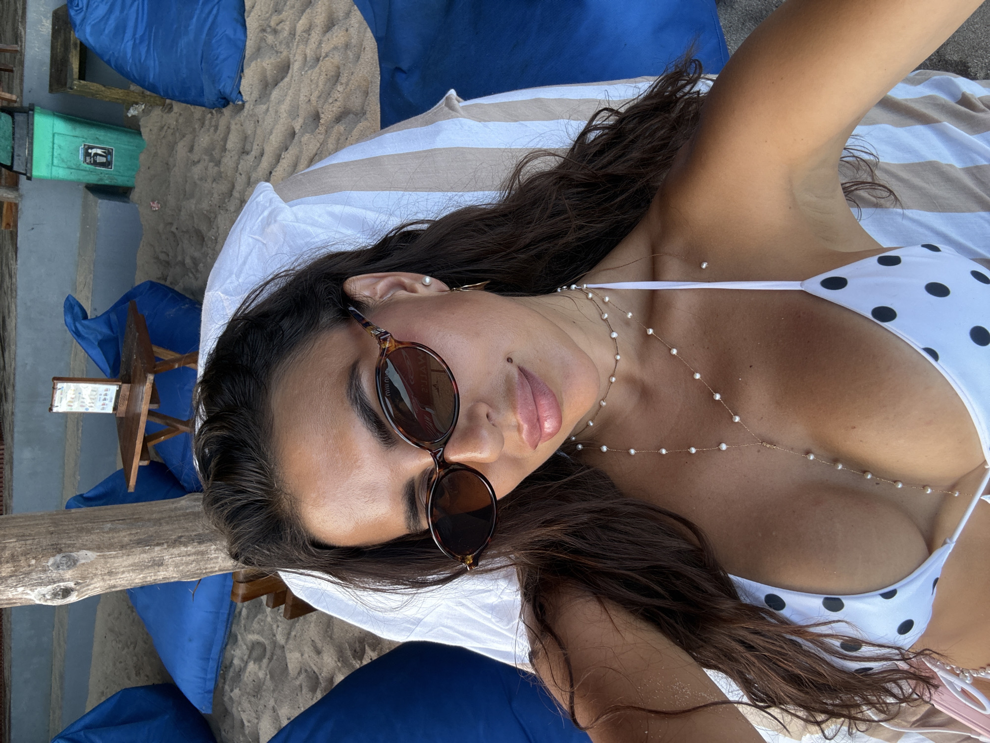 Woman sunbathes in polka-dot bikini at Kuta Selatan beach