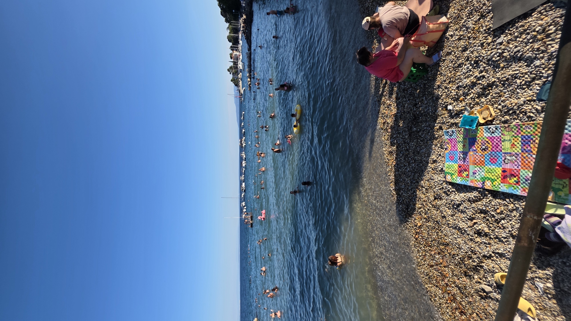 Sunny afternoon at a pebble beach and small harbor