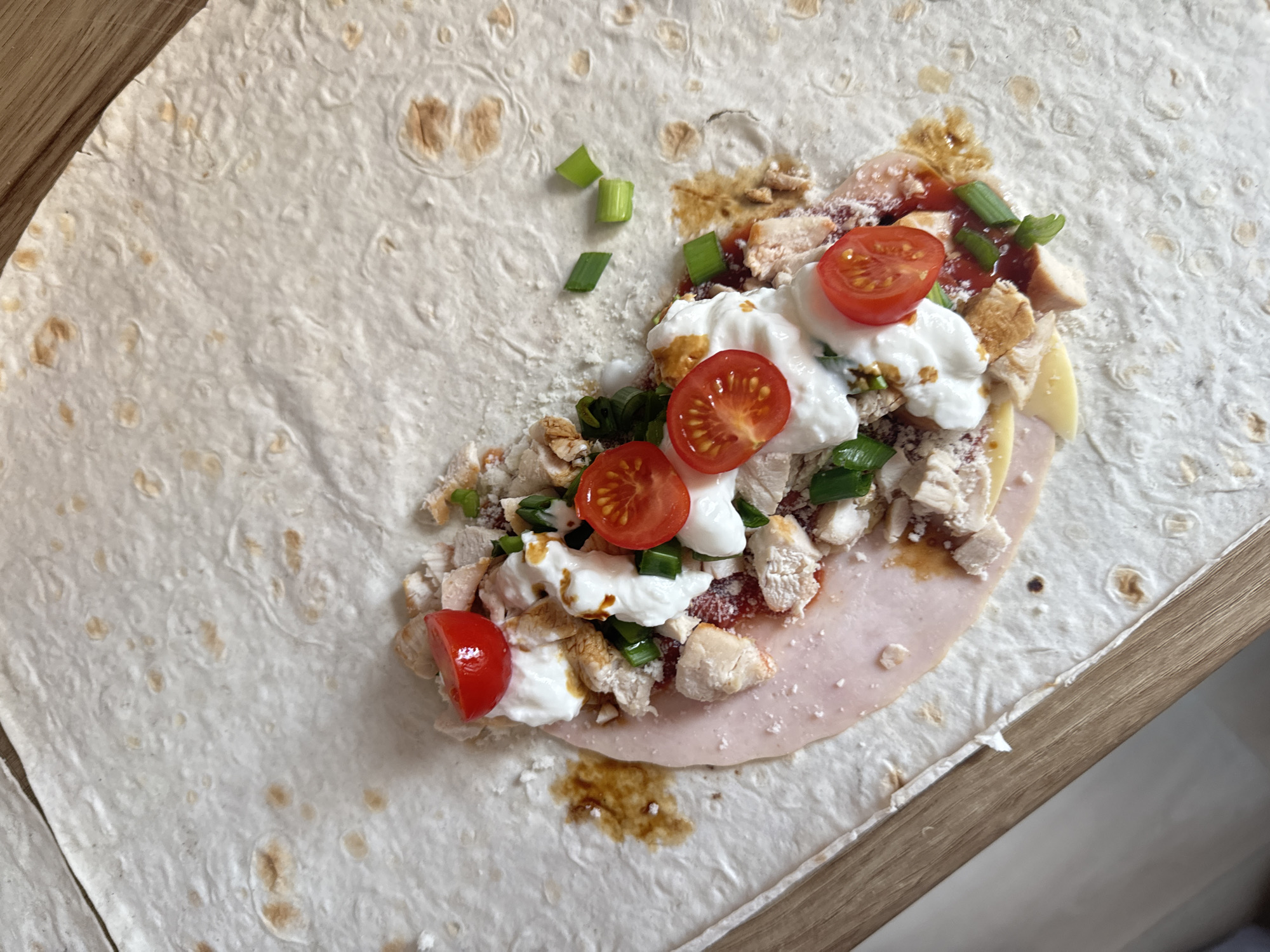 Early morning tortilla wrap preparation captured on wooden surface