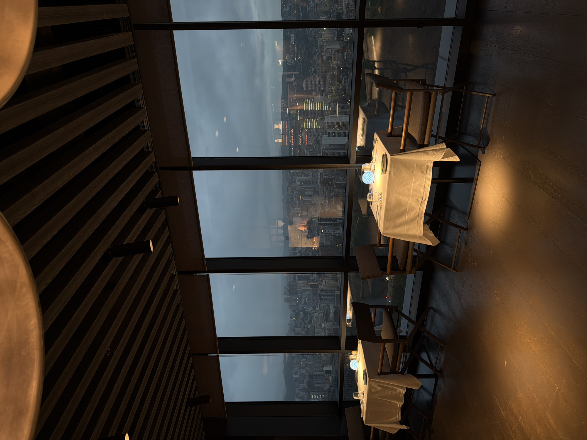 High-rise restaurant patron captures city skyline at dusk