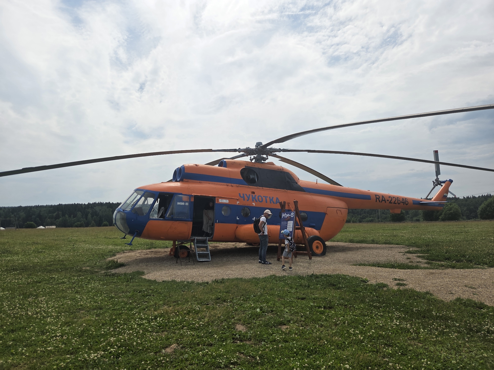 Chukotka-registered helicopter parked on gravel pad in Russian field