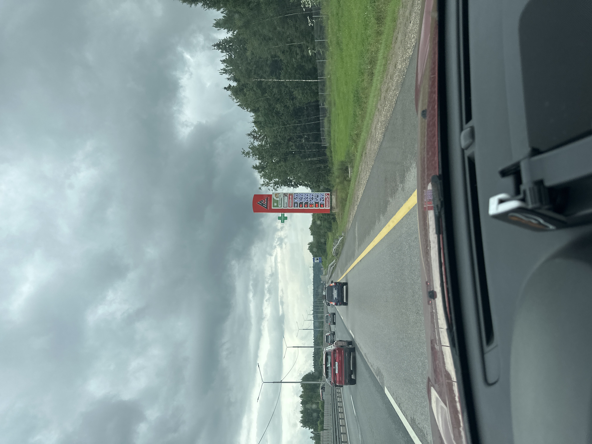 Highway drive under heavy clouds, roadside infrastructure in view