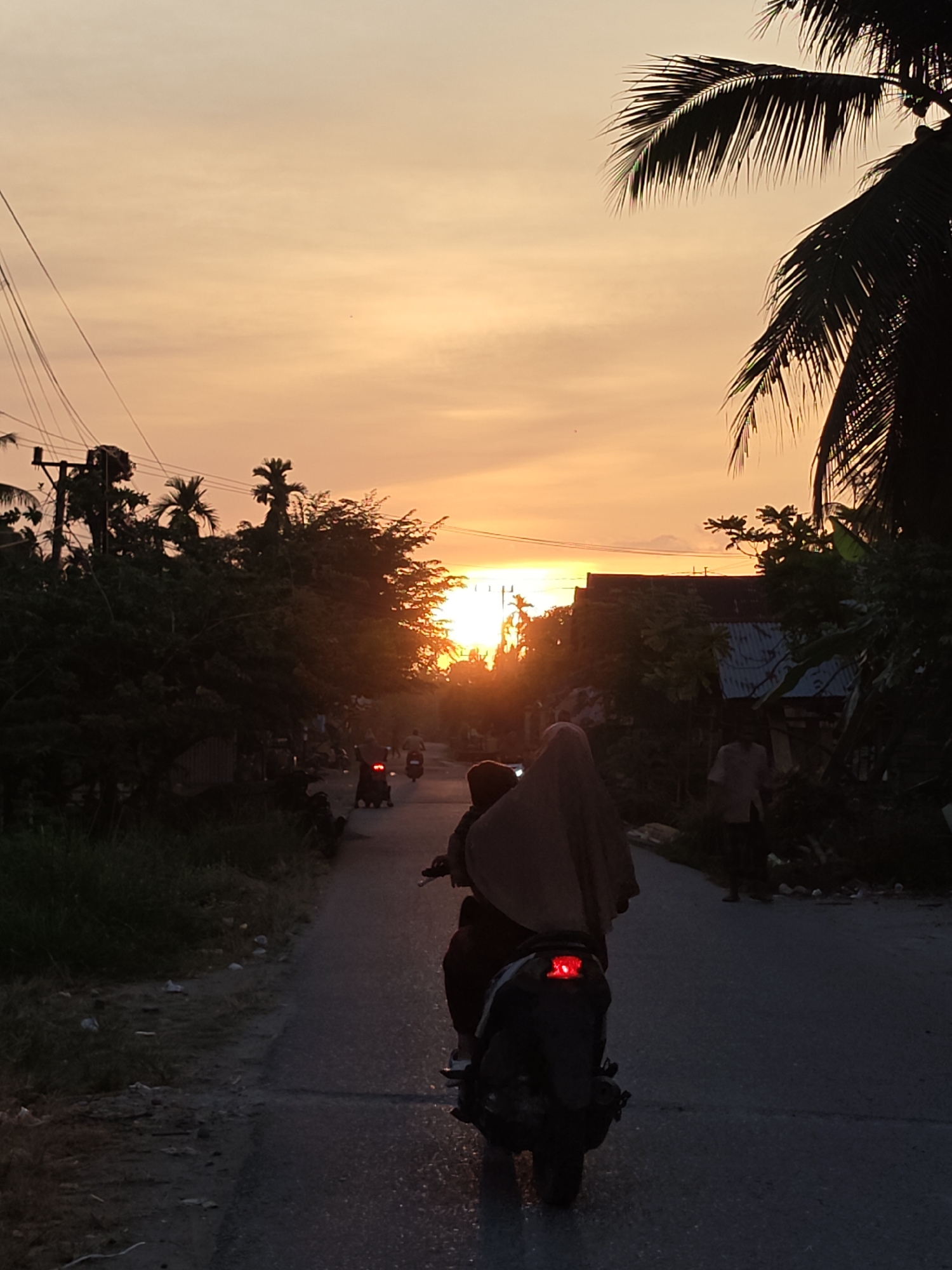 Motorcycles on a Lhokkulam road at golden hour