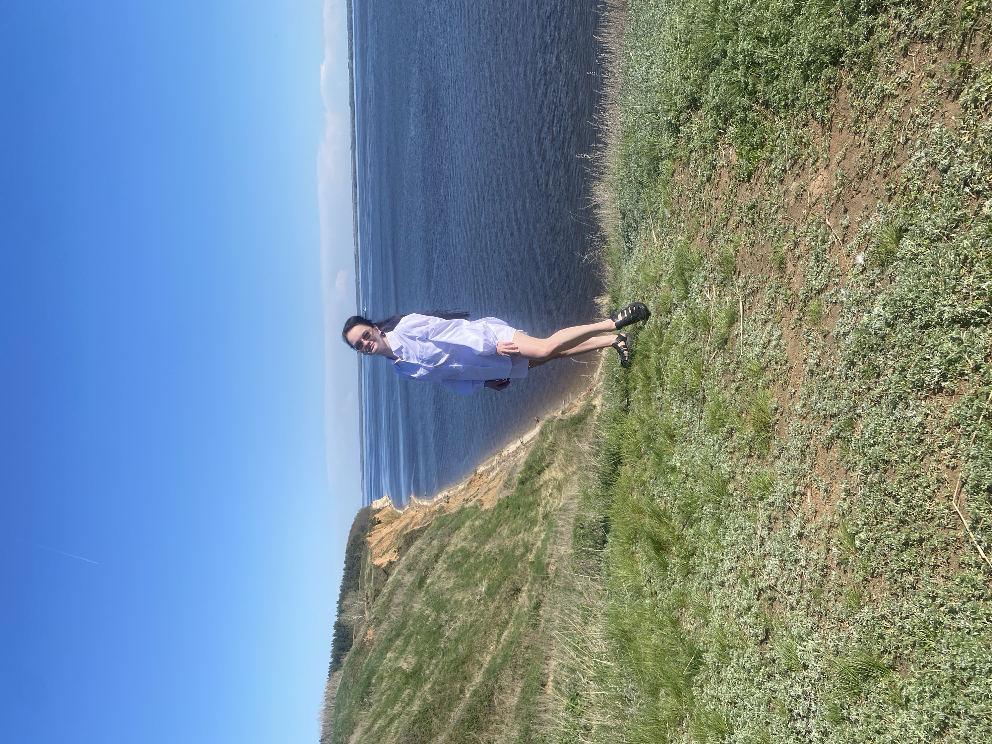 Woman stands on cliff overlooking water near Laishevo, Russia