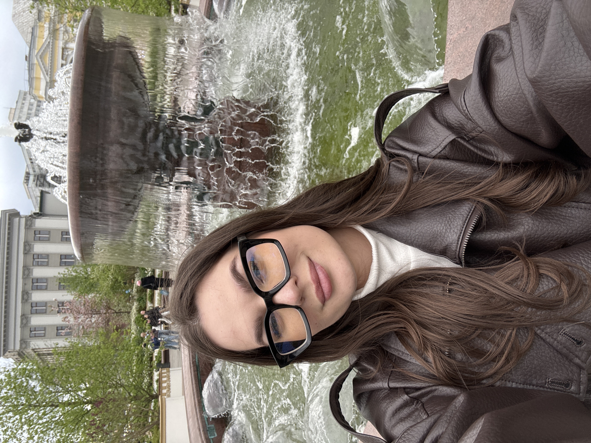 Woman photographs herself at Moscow fountain during afternoon session