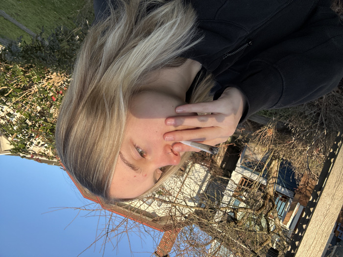 Young adult smokes on sunny Vancouver residential street