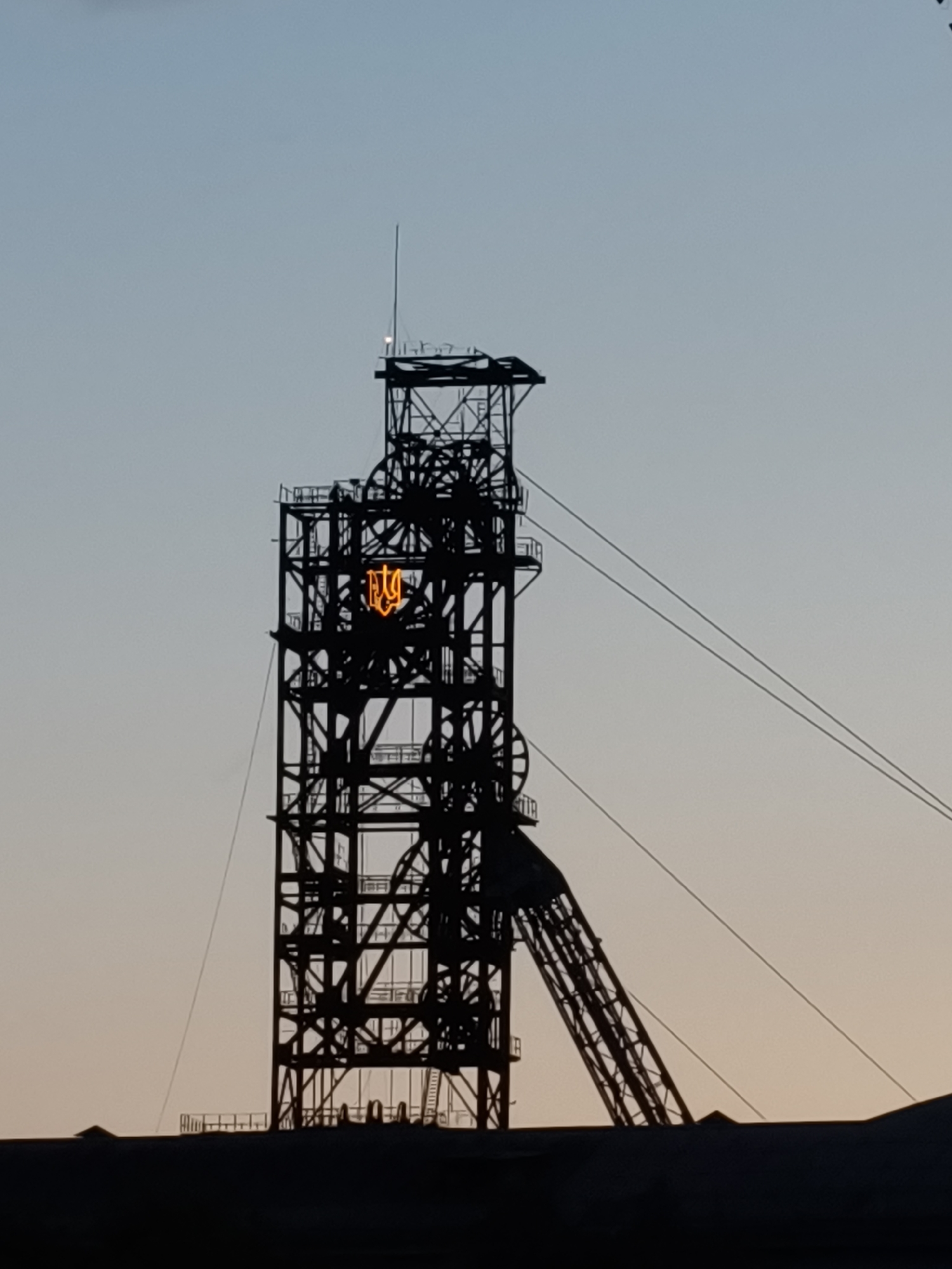 Industrial headframe silhouetted against twilight sky in Kryvyi Rih