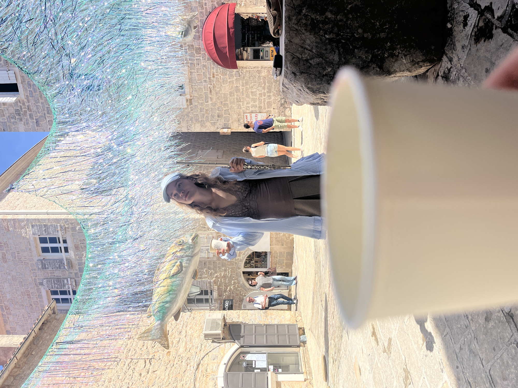 Street musician performs with flute in Budva old town