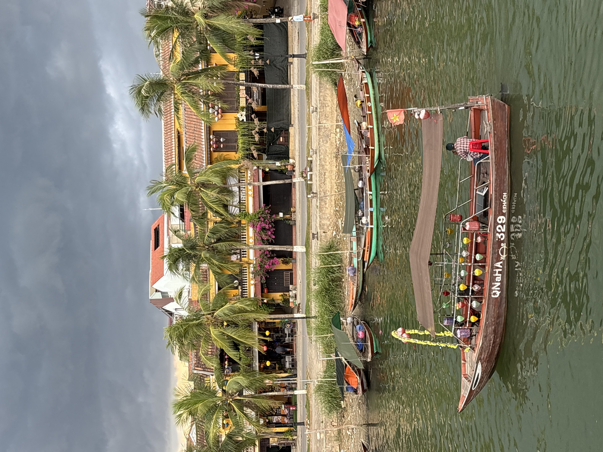 Canal life and stormy skies along Hội An's waterfront