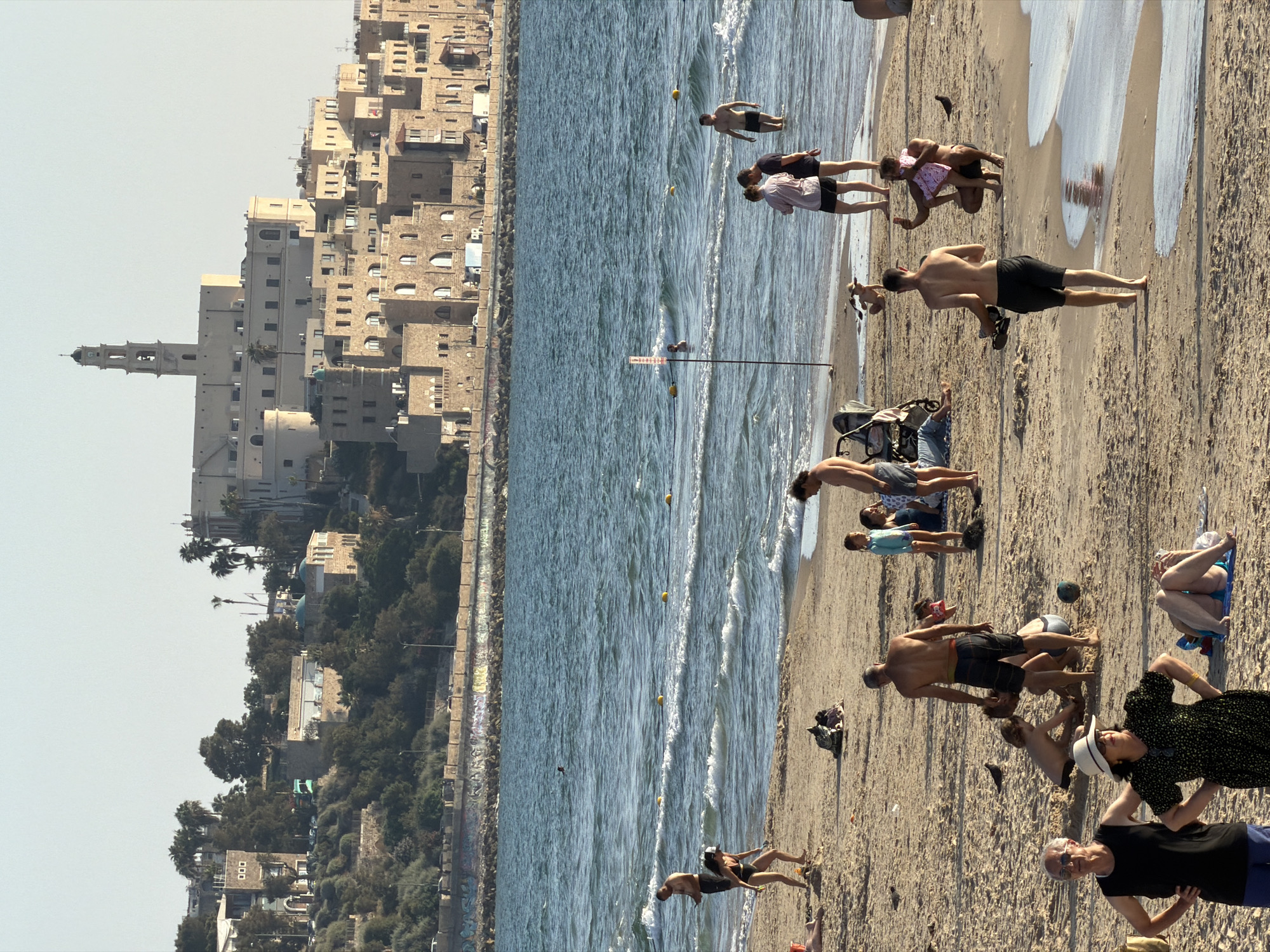 Friends photograph each other near Jaffa coast in Tel Aviv