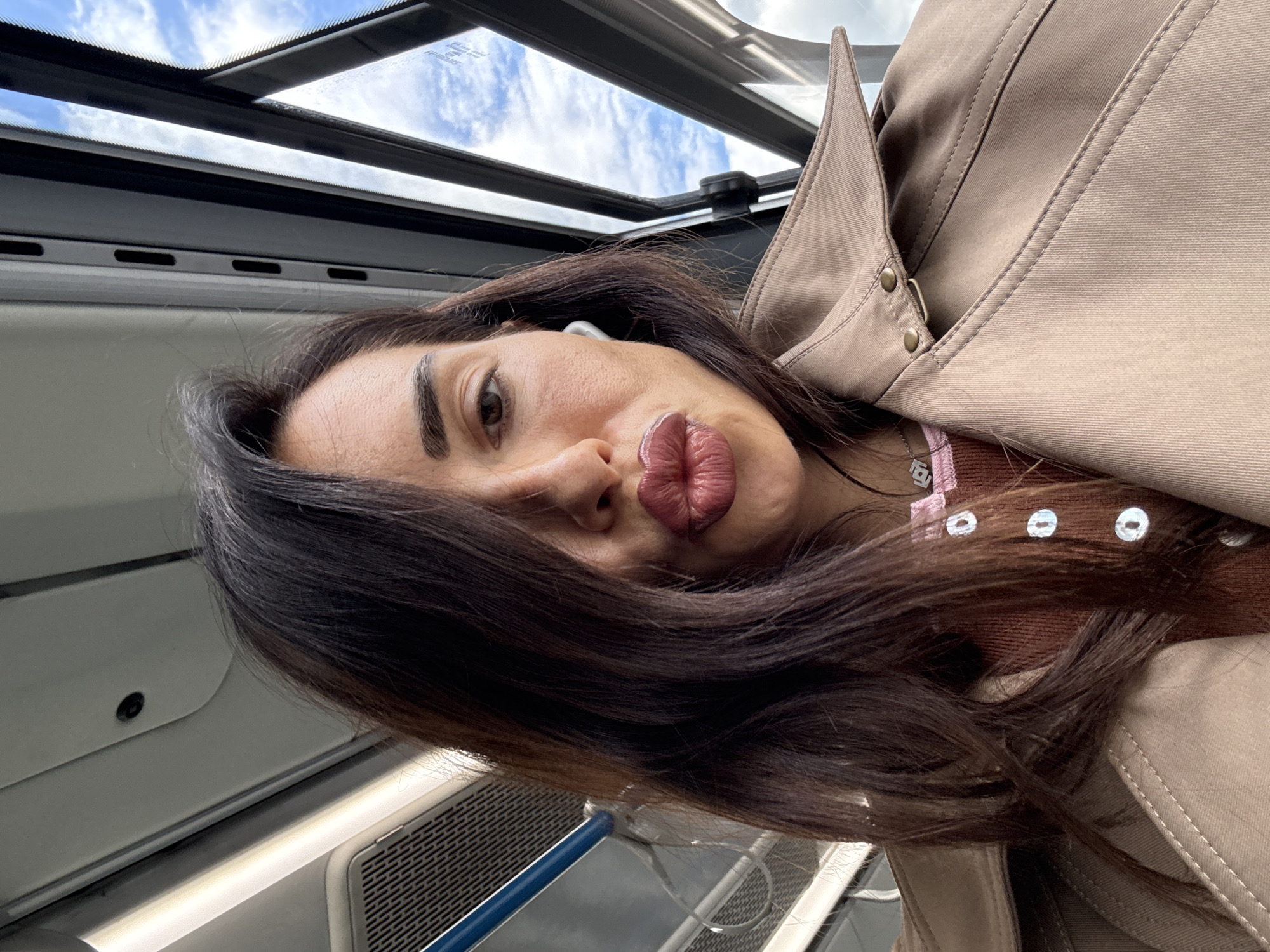 Selfie on Moscow public transit, trench coat and bold lip.
