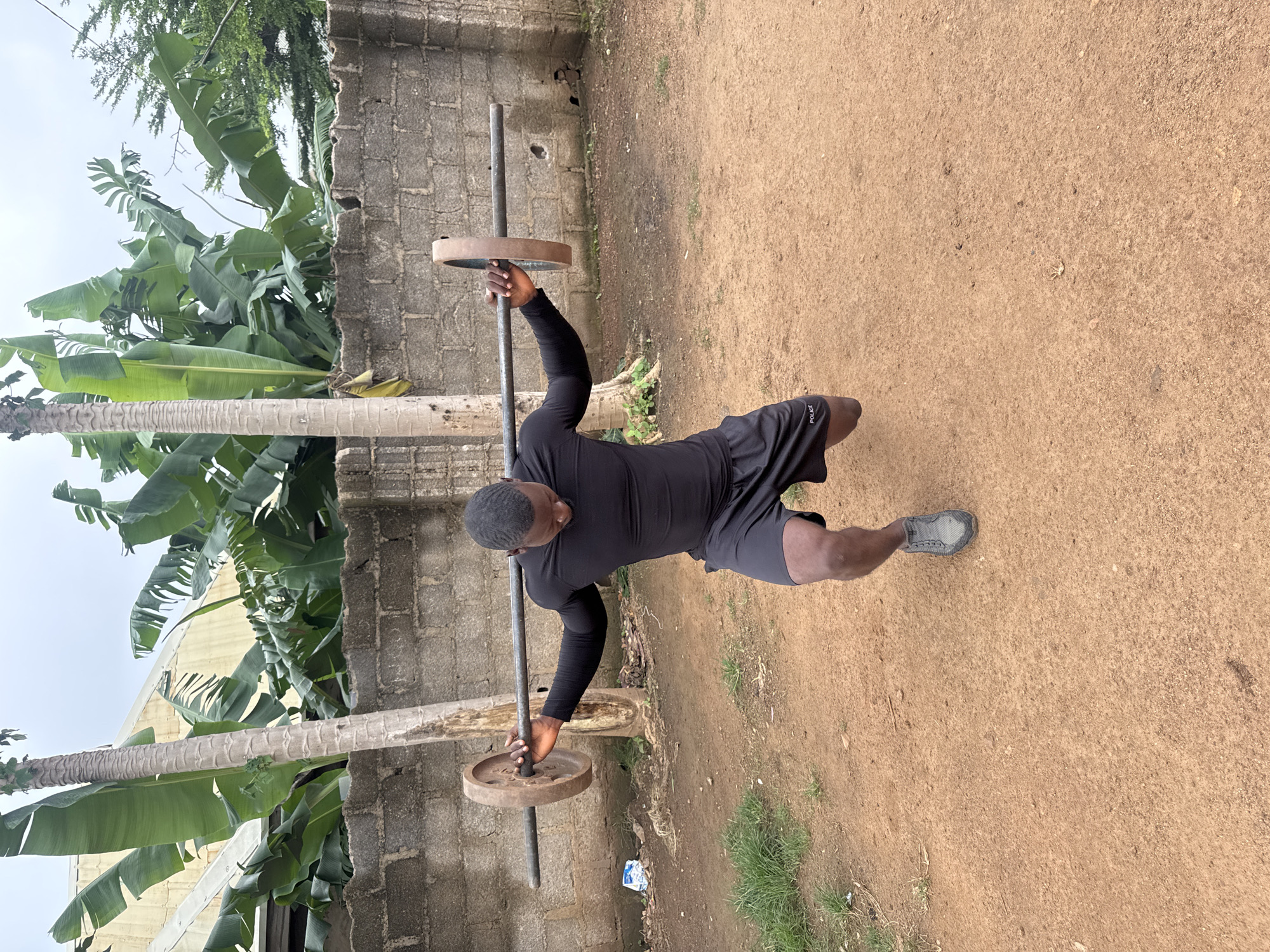 Weighted barbell lunges during an outdoor workout in Akwanga