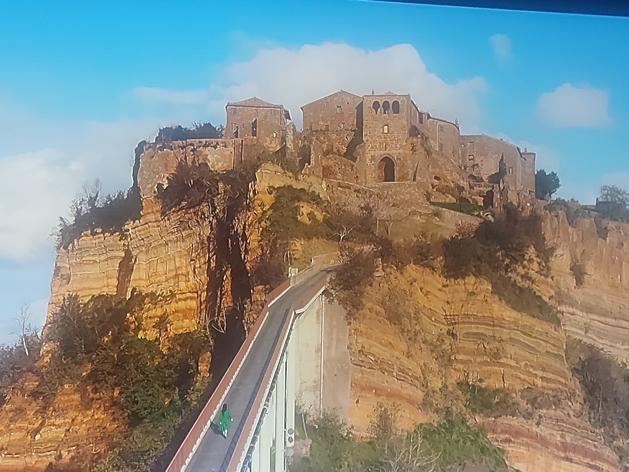 Cloaked Figure Crosses Bridge to Clifftop Citadel in Portugal