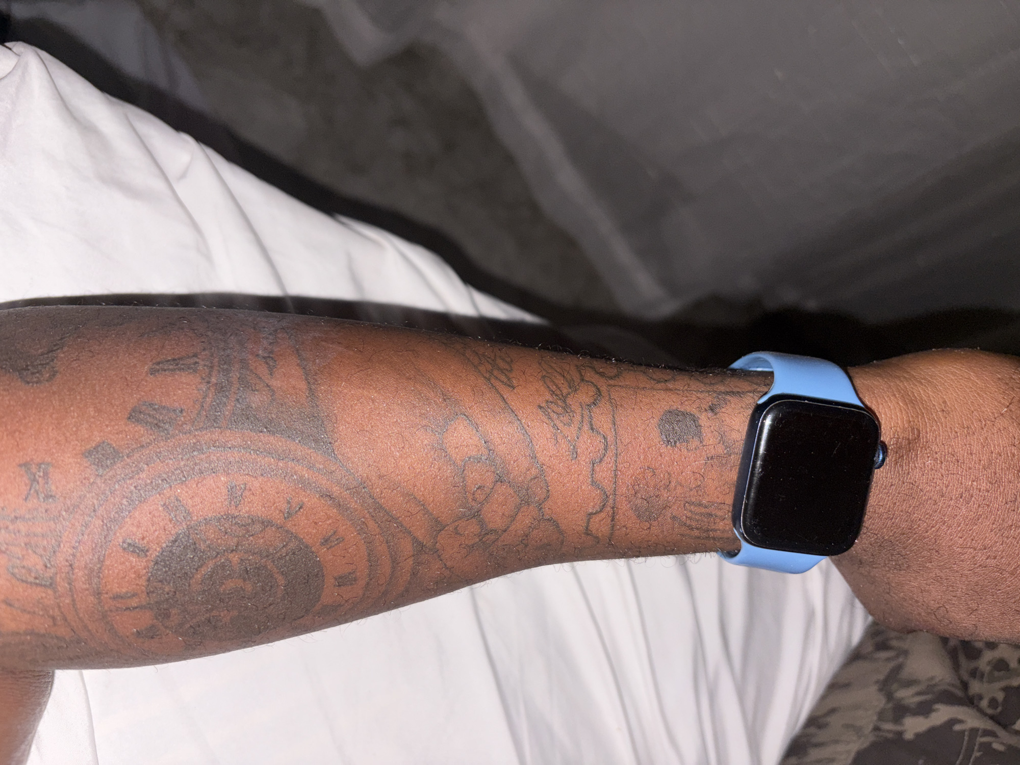 Tattooed person resting on bed photographed in Nigeria