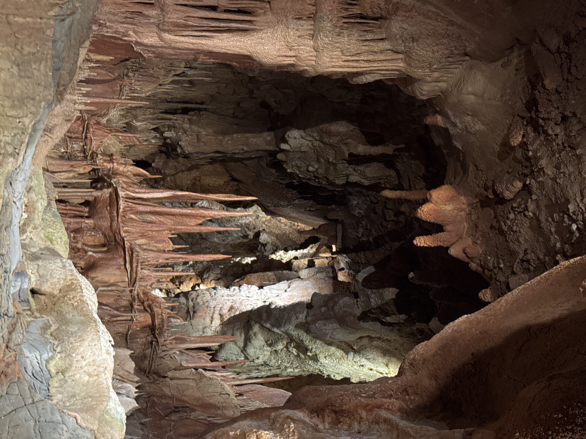 Cave interior with layered rock formations documented by witness