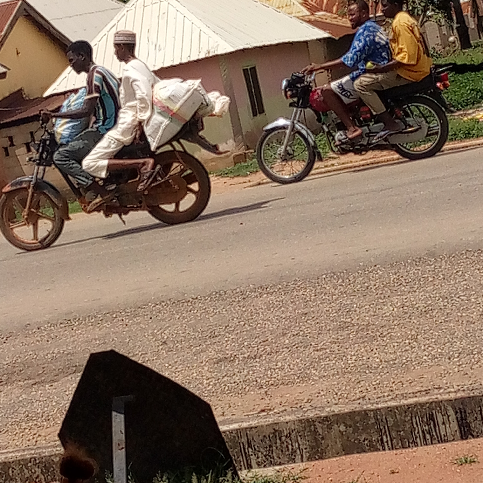 Motorcycles and pedestrians share street in Mararaba, Nigeria