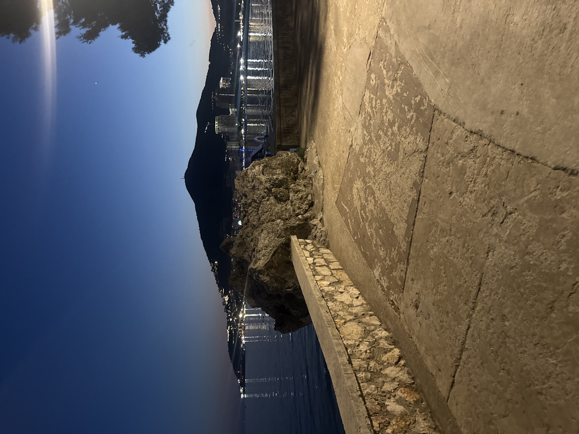 Budva Riviera at dusk — promenade, beach, and lit waterfront