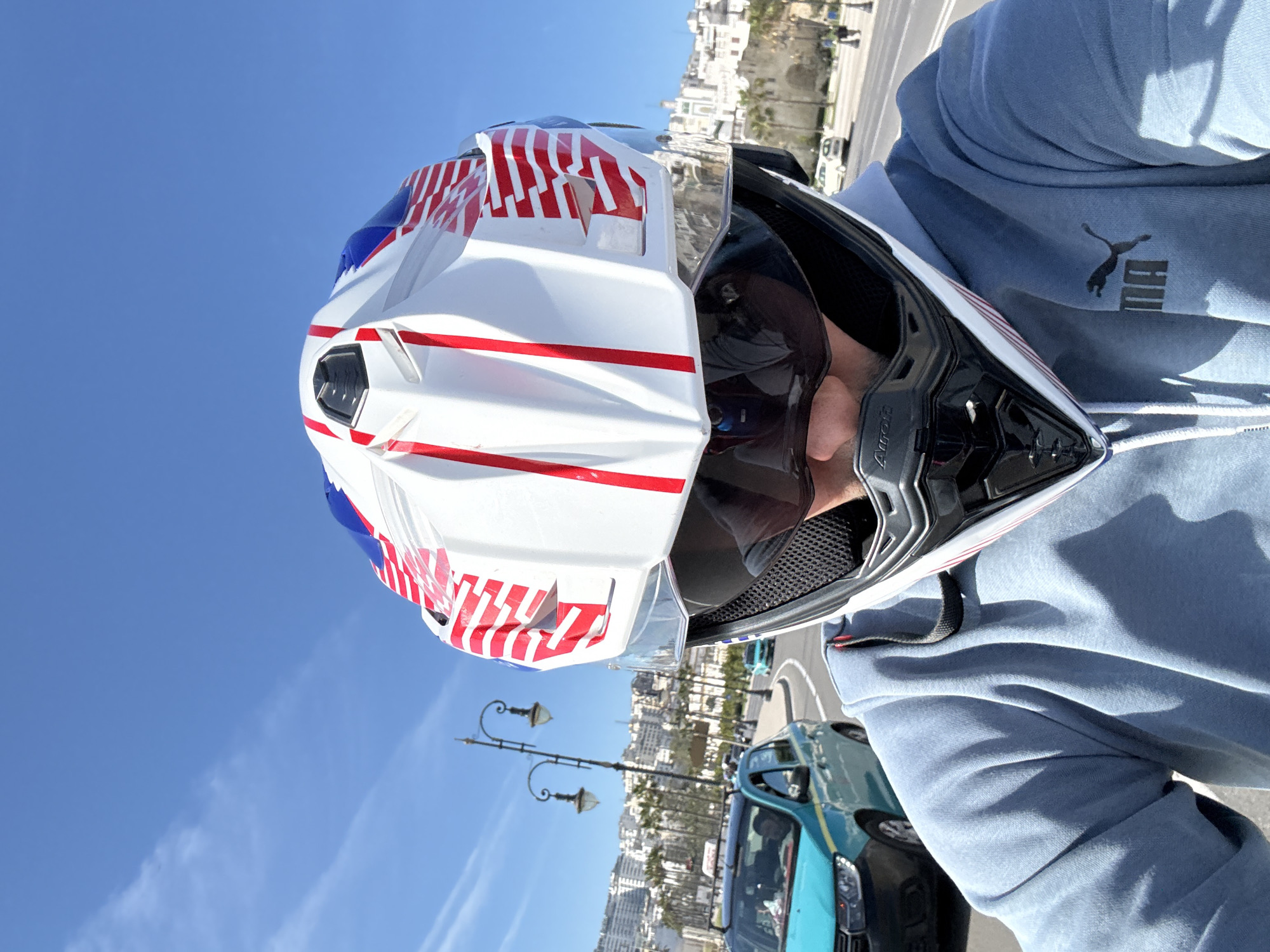 Motorcycle rider cruises Tangier streets in flag-themed helmet