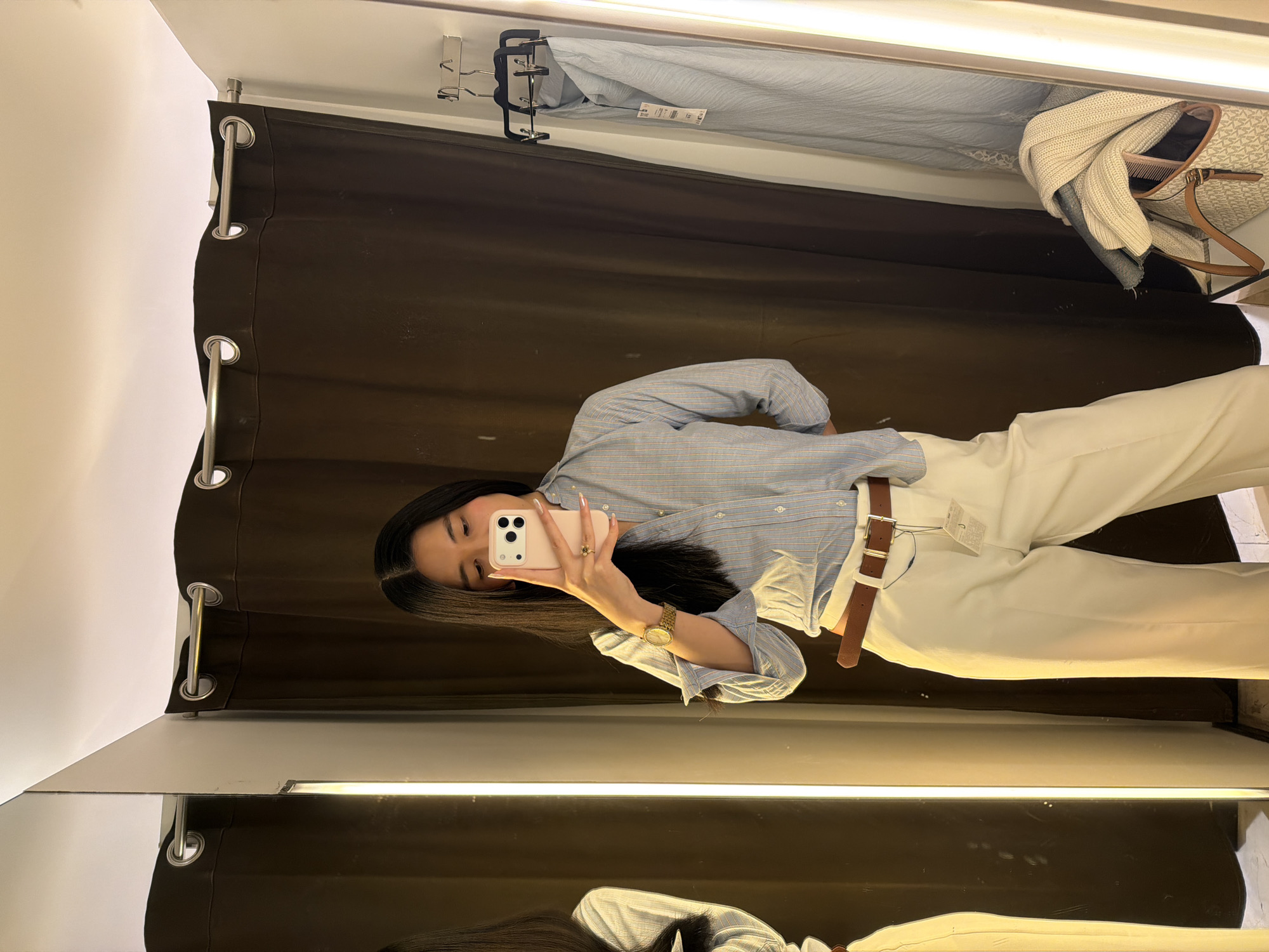 Person takes selfie in Paris store fitting room