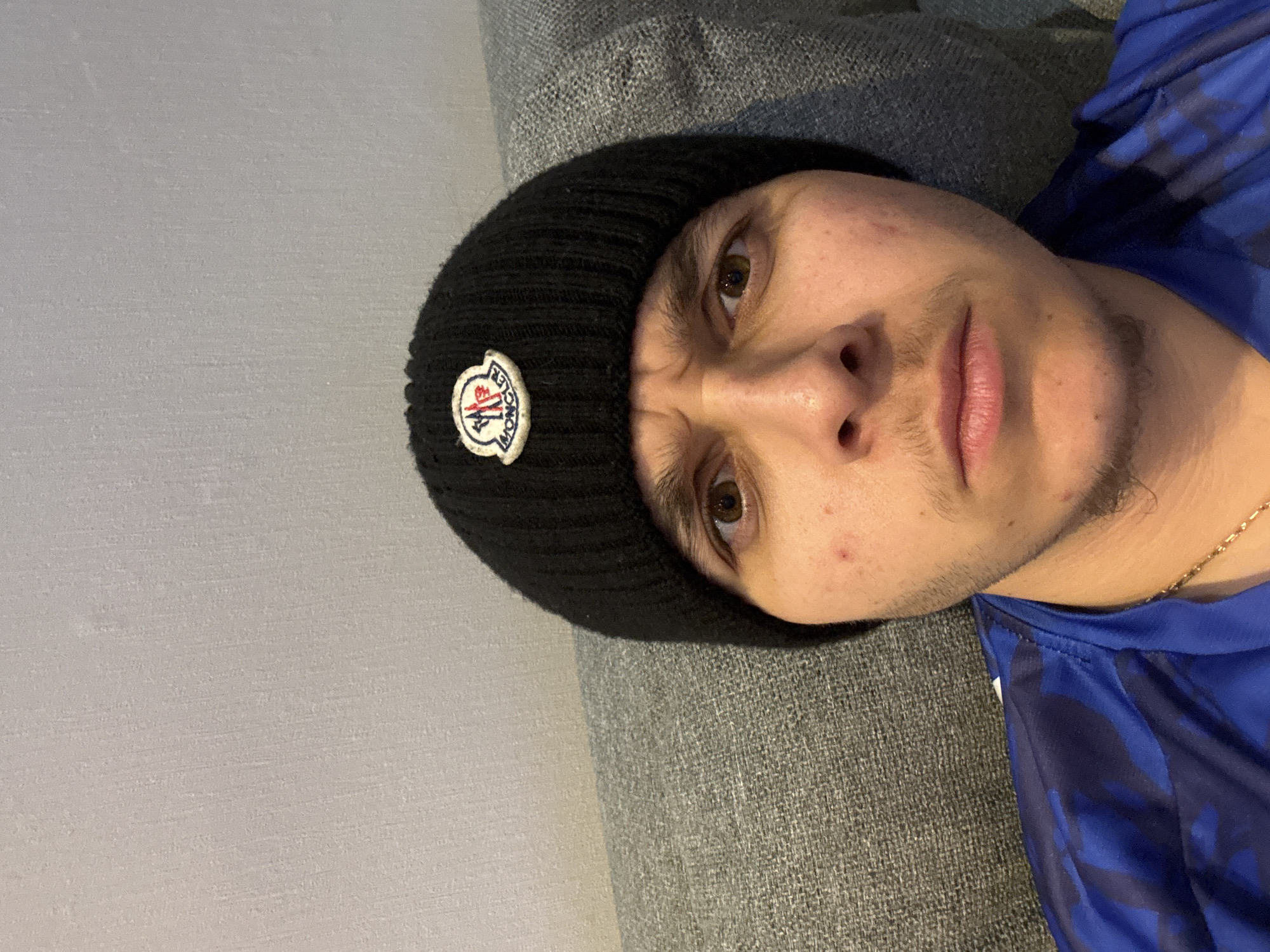 Man in designer beanie rests on couch in Bulgaria