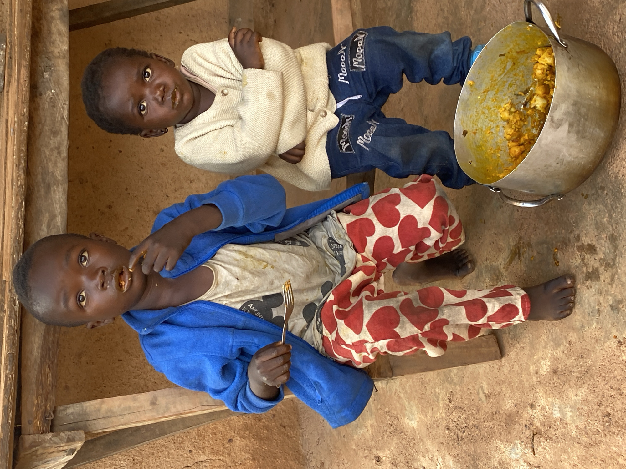 Kids on a bench with a pot of food, Jos, Nigeria