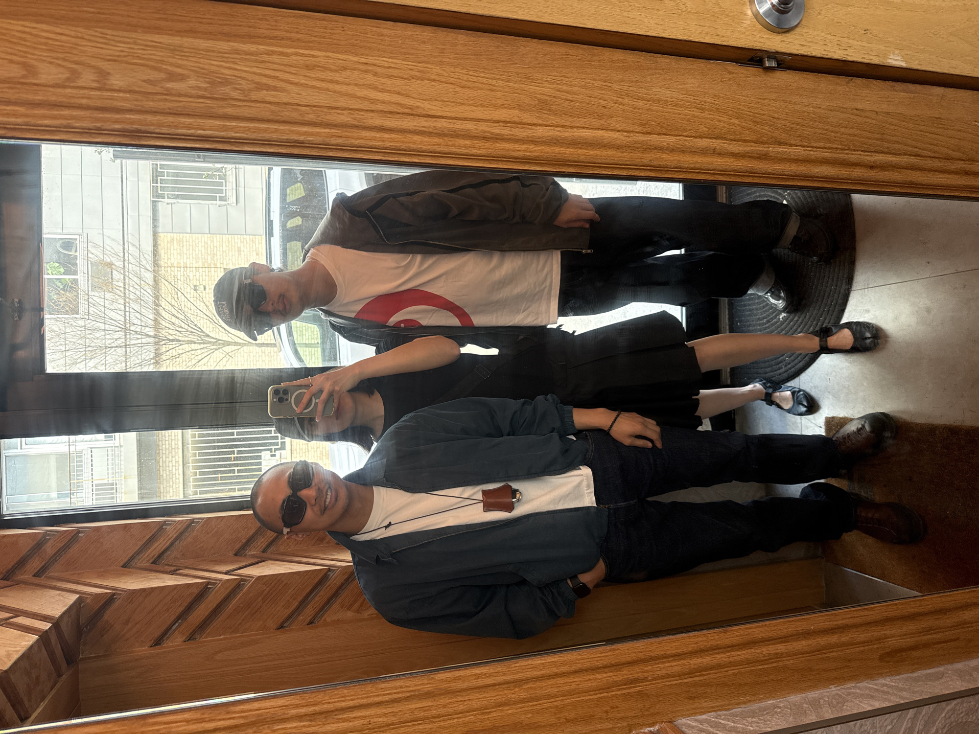 Three people reflected in NYC storefront window